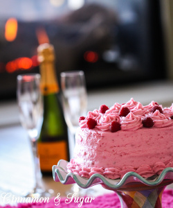 Raspberry cake is an almond scented white cake layered with raspberry buttercream and raspberry jam, with no artificial coloring. The perfect cake to celebrate any special occasion, especially Valentine's Day! Recipe shared with permission granted by Lucy Burdette, author of Fatal Reservations. 