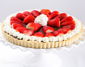 A flaky, buttery crust provides the base for a decadently, rich Chocolate Truffle Tart that is garnished with juicy, red strawberries and sweetened whipped cream. Chocolate and strawberries are the perfect combination to impress your family and friends! 