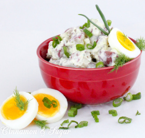 Daisy Carpenter's Secret Potato Salad with Dill combines red potatoes, for texture & color, with creamy, tangy mayo & sour cream. A generous amount of dill and scallions provide fresh flavor. Recipe shared from SOMETHING BORROWED, SOMETHING MEWED by Bethany Blake.