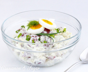 Daisy Carpenter's Secret Potato Salad with Dill combines red potatoes, for texture & color, with creamy, tangy mayo & sour cream. A generous amount of dill and scallions provide fresh flavor. Recipe shared from SOMETHING BORROWED, SOMETHING MEWED by Bethany Blake.