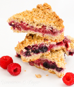 Berry Crumb Bars start with an easy to make dough that serves as both the crust and crumb topping, while a generous amount of juicy berries provide a jammy filling. Recipe shared from cozy mystery SOUTHERN SASS AND KILLER CRAVINGS by Kate Young.