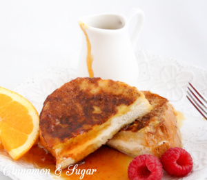 Stuffed French Toast are slices of French bread stuffed with orange zest and cream cheese. Paired with Honey Orange Syrup makes it a perfect breakfast! Recipe shared with permission granted by Kate Carlisle, author of THE BOOK SUPREMACY.