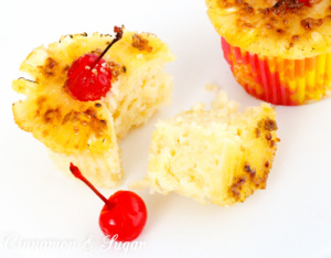 A rich, buttery pineapple cake topped with a caramelized pineapple ring and maraschino cherry make Pineapple Upside-Down Cupcakes perfect for hot summer months! Recipe shared with permission granted by Jenn McKinlay, author of DYING FOR DEVIL'S FOOD.