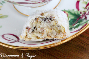 Cranberry Walnut Cookie Balls combine the crunch of walnuts in a shortbread-style cookie along with the tart sweetness of cranberries. Rolled in fluffy powdered sugar, these are a welcome addition to any holiday cookie platter. Recipe shared with permission granted by Meg Macy, author of HAVE YOURSELF A BEARY LITTLE MURDER. 