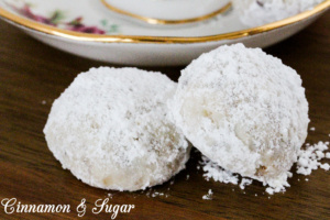 Cranberry Walnut Cookie Balls combine the crunch of walnuts in a shortbread-style cookie along with the tart sweetness of cranberries. Rolled in fluffy powdered sugar, these are a welcome addition to any holiday cookie platter. Recipe shared with permission granted by Meg Macy, author of HAVE YOURSELF A BEARY LITTLE MURDER. 