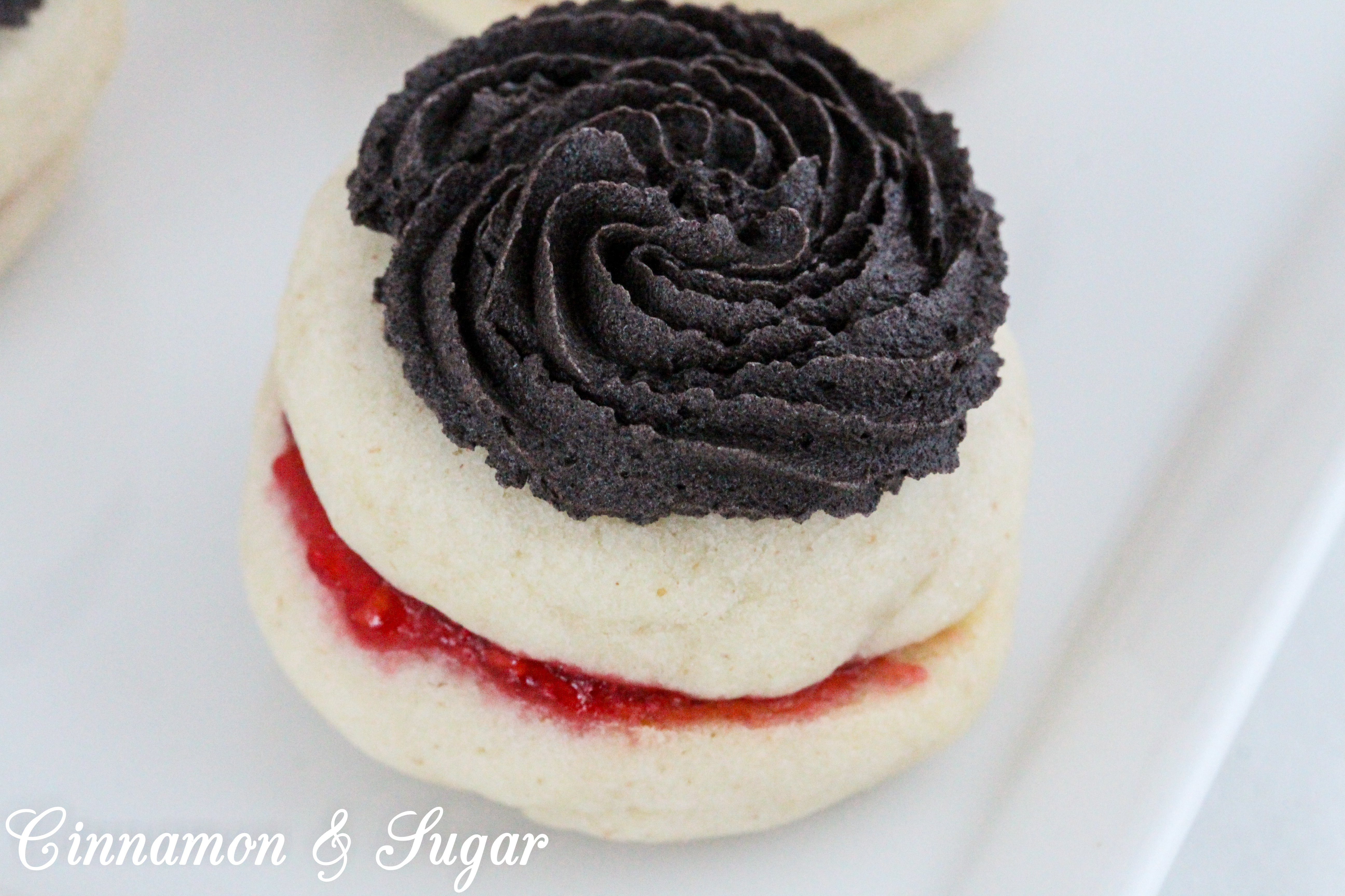 Mom’s Antoinettes are buttery, almond-flavored shortbread-style cookies that are sandwiched around raspberry jam and topped with dark chocolate buttercream. Recipe shared with permission granted by Ellie Alexander, author of A CUP OF HOLIDAY FEAR. 