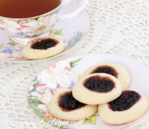 Mulberry Thumbprint Cookies are a shortbread-style cookie with a dollop of mulberry jam providing a beautiful dark purple jewel in the middle of the baked cookie. Recipe shared with permission granted by Sharon Farrow, author of MULBERRY MISCHIEF. 