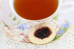 Mulberry Thumbprint Cookies are a shortbread-style cookie with a dollop of mulberry jam providing a beautiful dark purple jewel in the middle of the baked cookie. Recipe shared with permission granted by Sharon Farrow, author of MULBERRY MISCHIEF. 