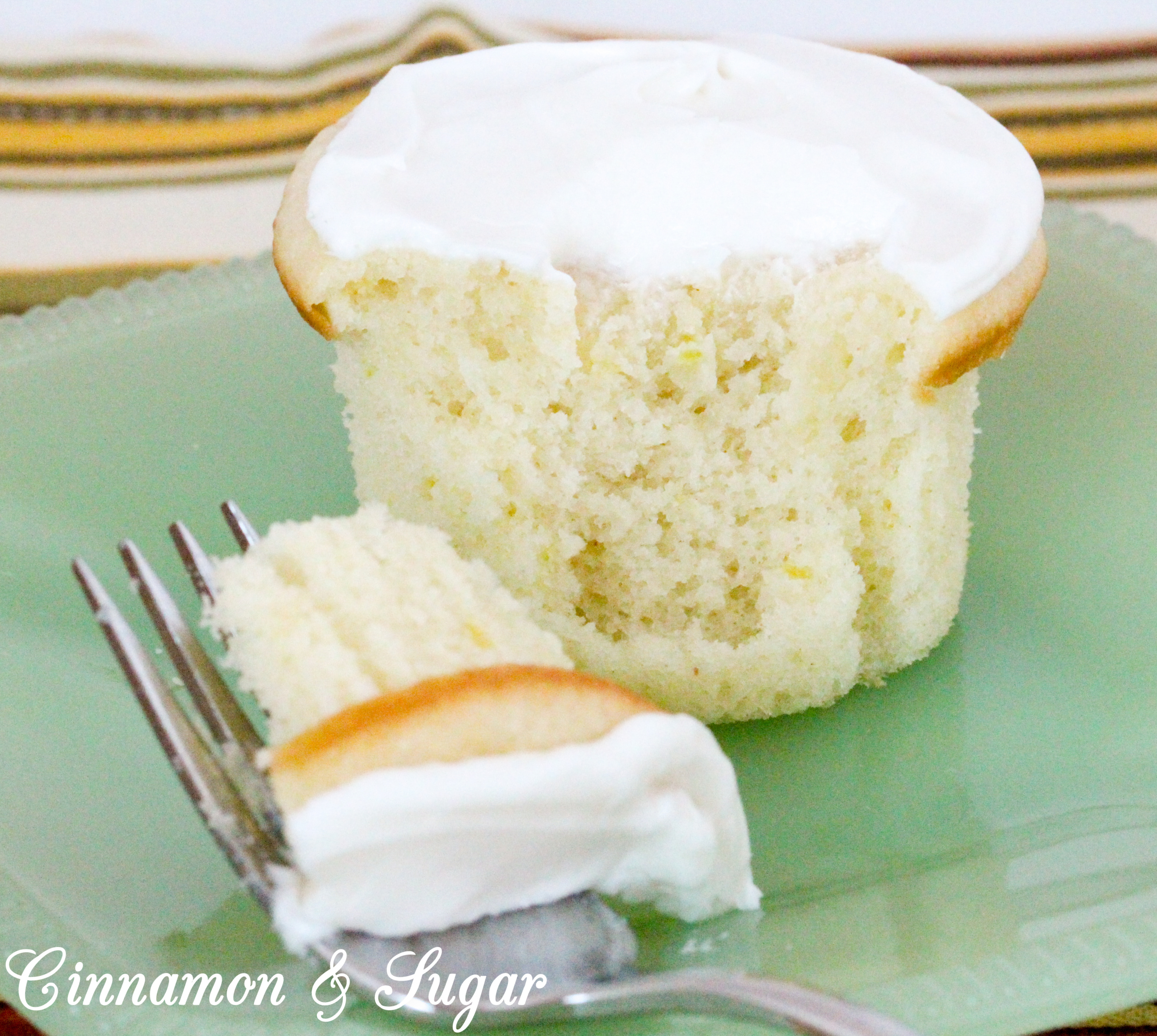 Lemony cream cheese frosting tops little lemon cakes that are super moist thanks to a generous dollop of sour cream. Perfect for afternoon tea or brunch! Recipe shared with permission granted by Maureen Klovers, author of MURDER IN THE MOONSHINE. 