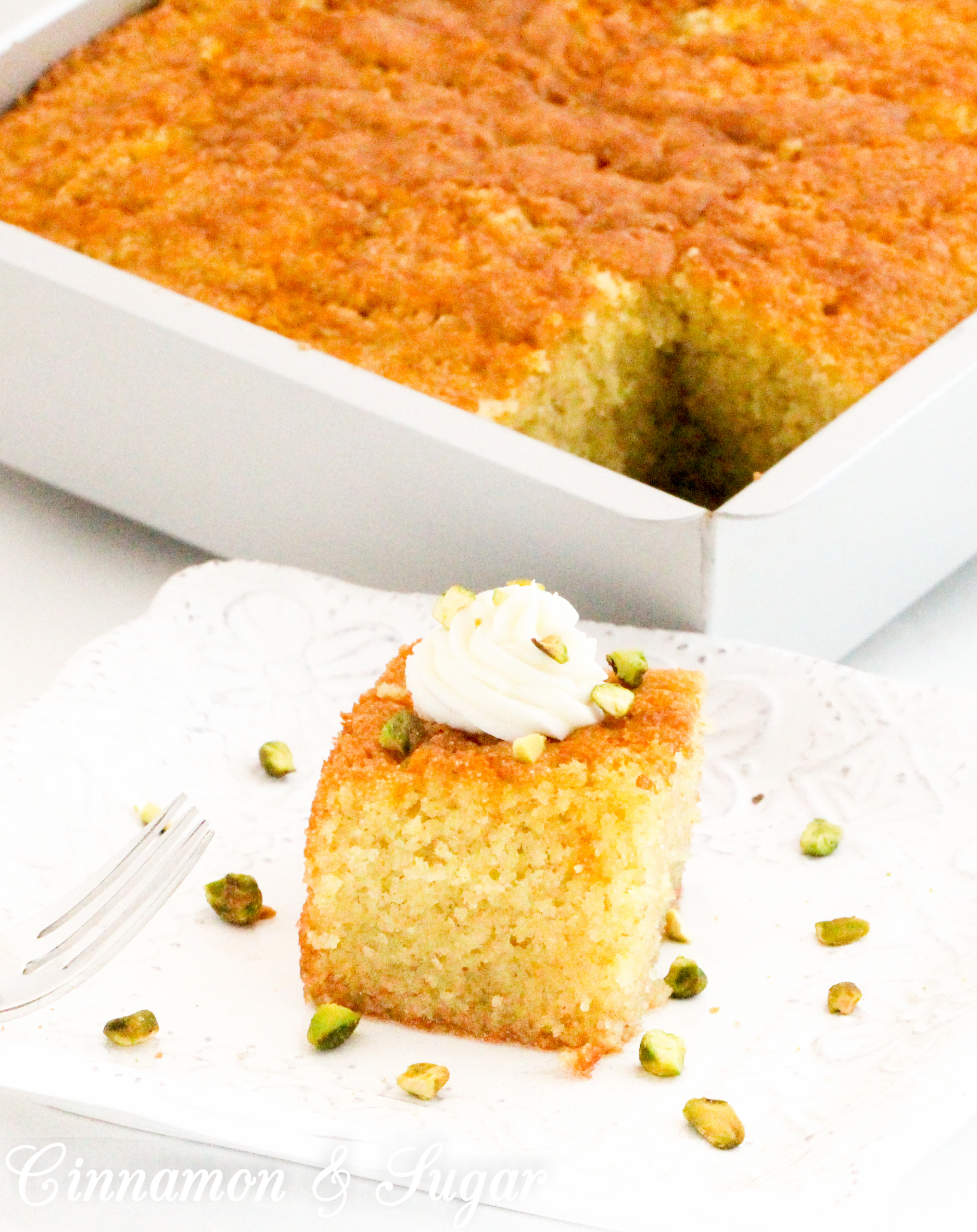 Greek Farina Cake is made from pantry and refrigerated staples and then drenched in a honey, orange zest syrup, which results in a supremely moist and flavorful dessert. Recipe shared with permission granted by Maria DiRico, author of HERE COMES THE BODY. 