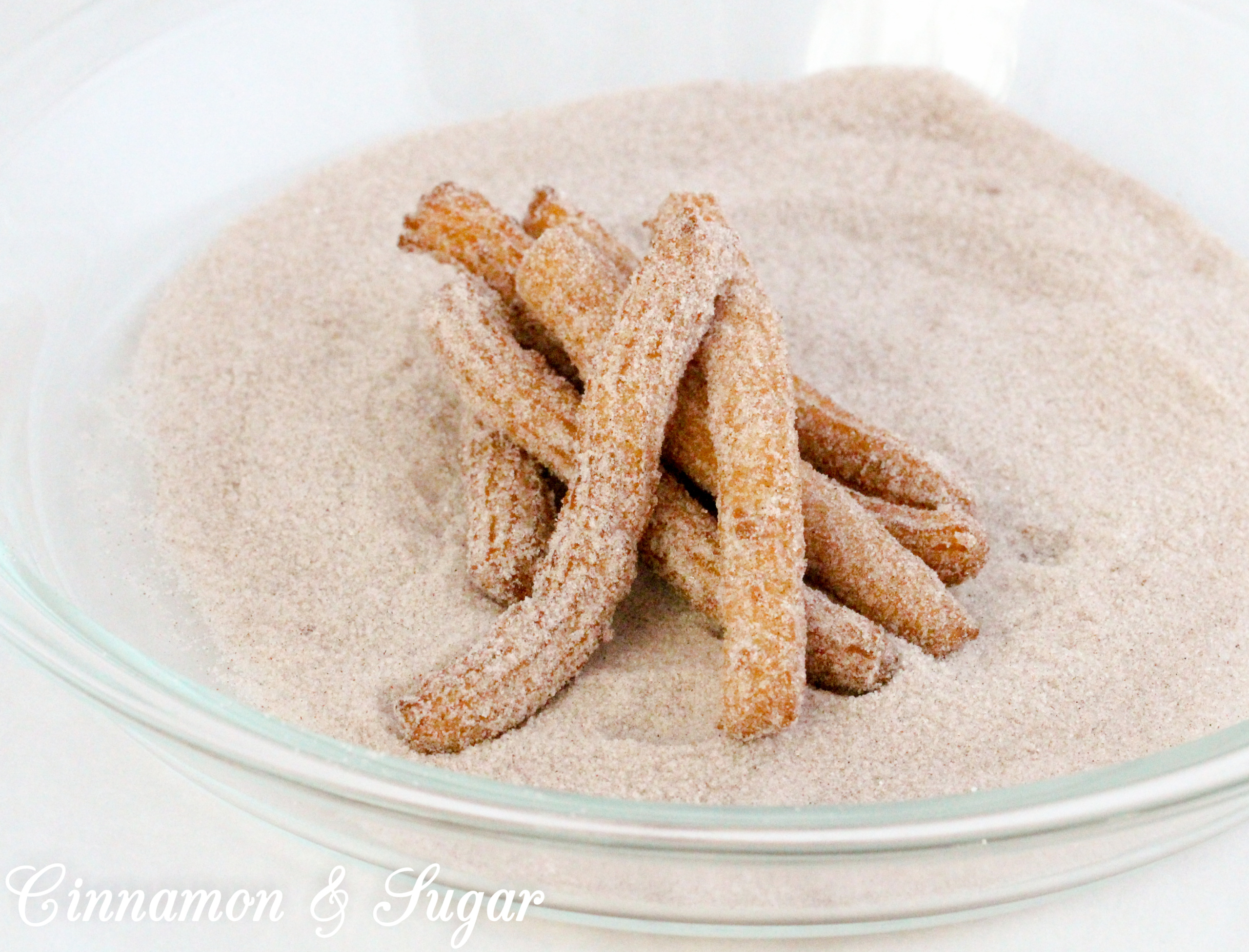 It's not that difficult to make fresh, hot from the skillet, churros. Rolled in cinnamon and sugar, and then served with warm Mexican chocolate dipping sauce, this dessert is a scrumptious treat! Recipe shared with permission granted by S.C. Perkins, author of LINEAGE MOST LETHAL. 