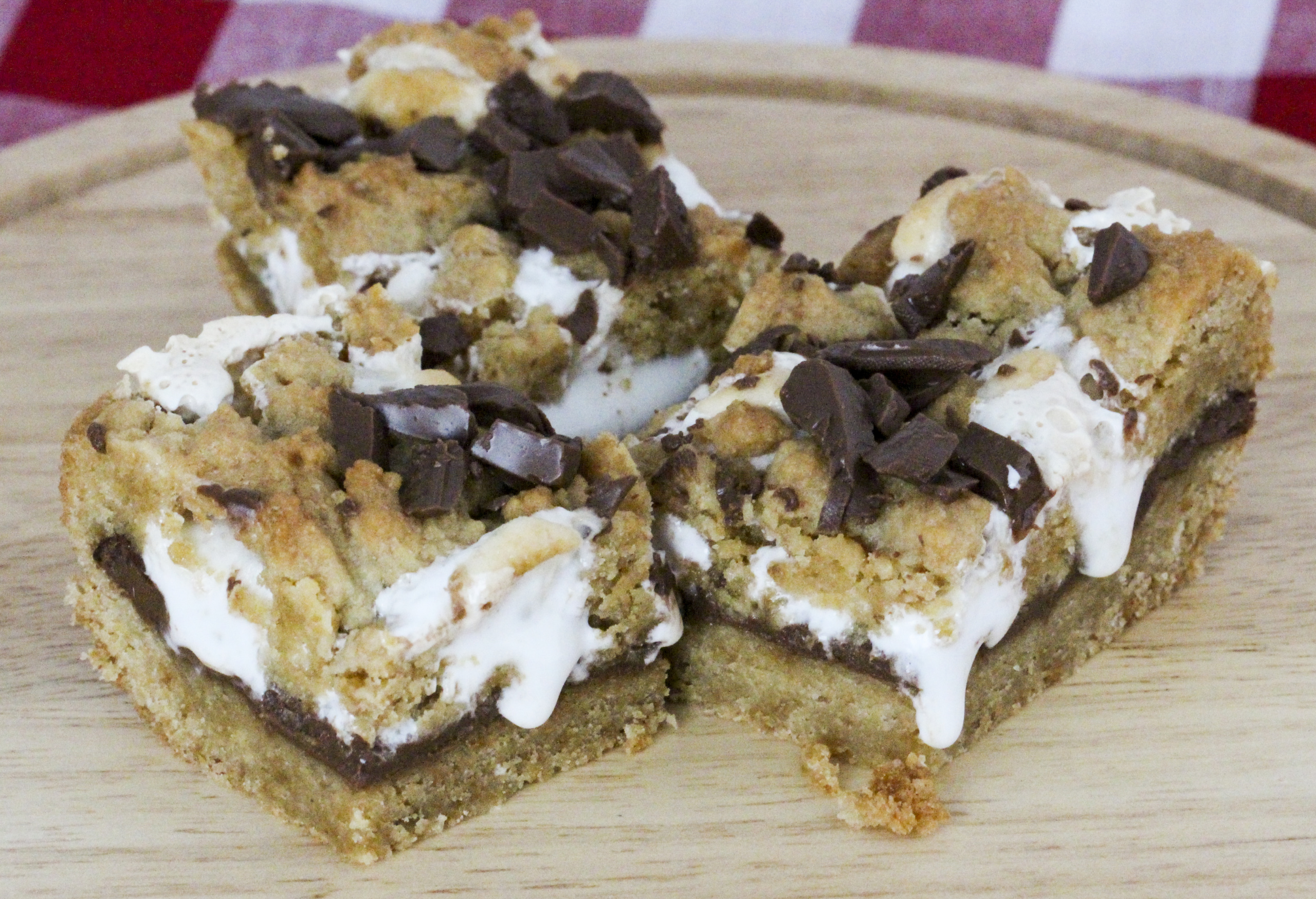 No campfires required! S'mores Cookie Bars have a graham cracker cookie dough base and topping, and a rich layer of iconic chocolate bars with gooey marshmallows. Recipe created by Cinnamon & Sugar for Catherine Bruns, author of KNEE DEEP IN DOUGH.