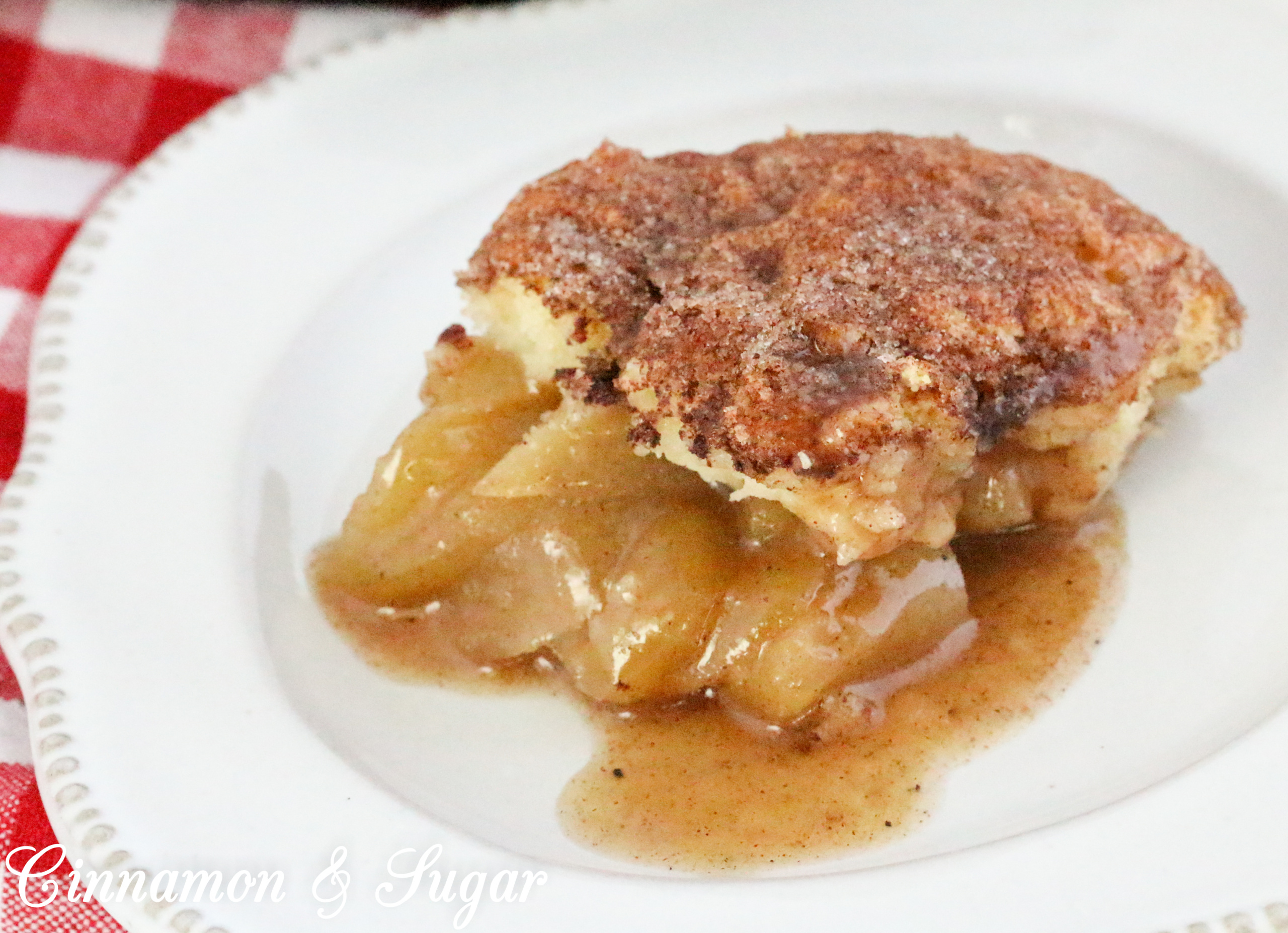 While rustic, Dutch Apple Cobbler in a Cast-Iron Skillet is scrumptiously delicious from the cinnamon-y tender apples to the buttery cinnamon sugar crunch coating the rich, biscuit-like topping. Recipe shared with permission granted by Cheryl Hollon, author of STILL KNIFE PAINTING.