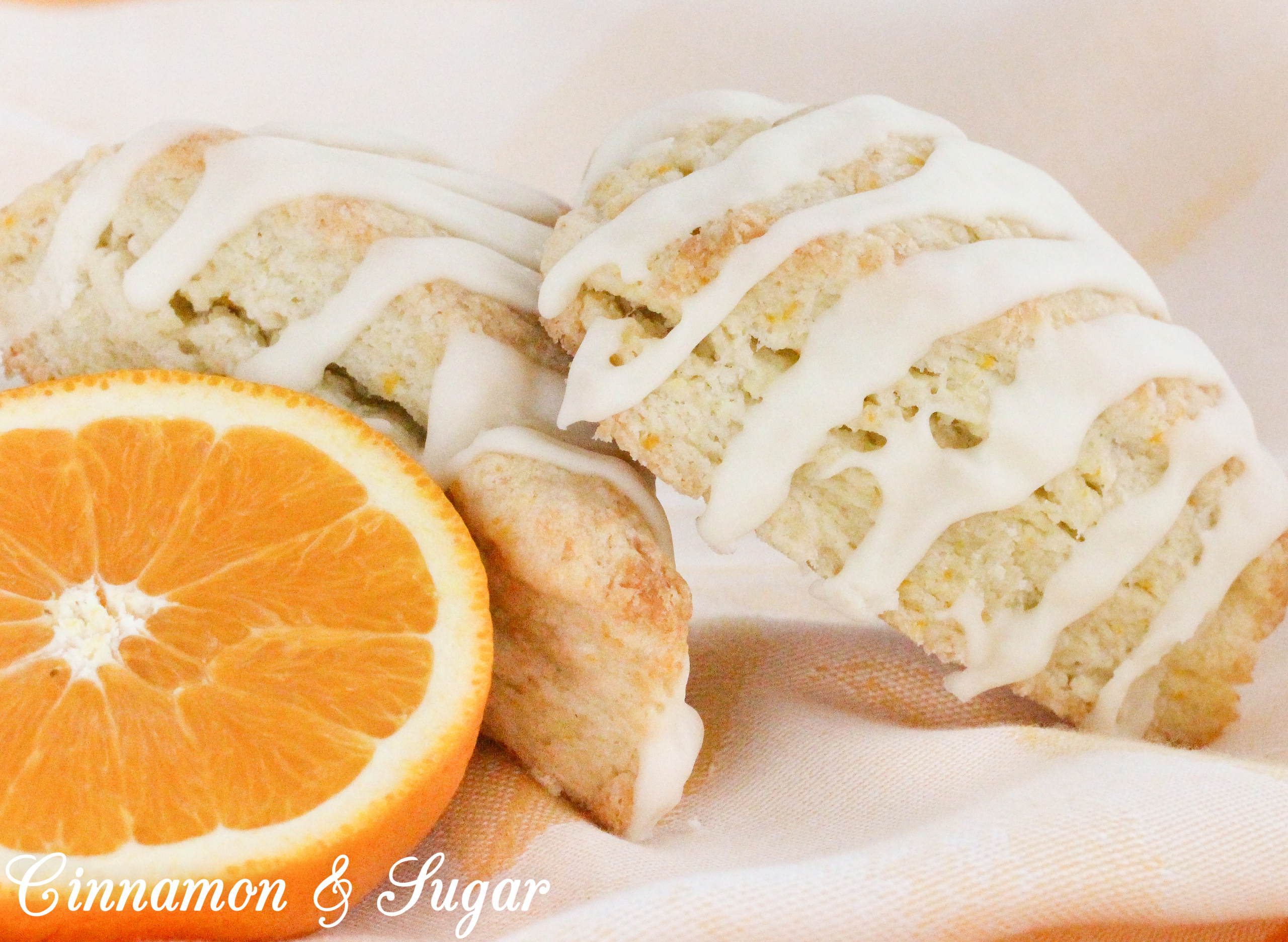 These flaky Orange Scones are easy to mix up and the sweet, orange glaze boosts the wow factor. Scrumptious on their own, a smear of orange marmalade would make them even more delectable! Recipe shared with permission granted by Maddie Day, author of NACHO AVERAGE MURDER. 