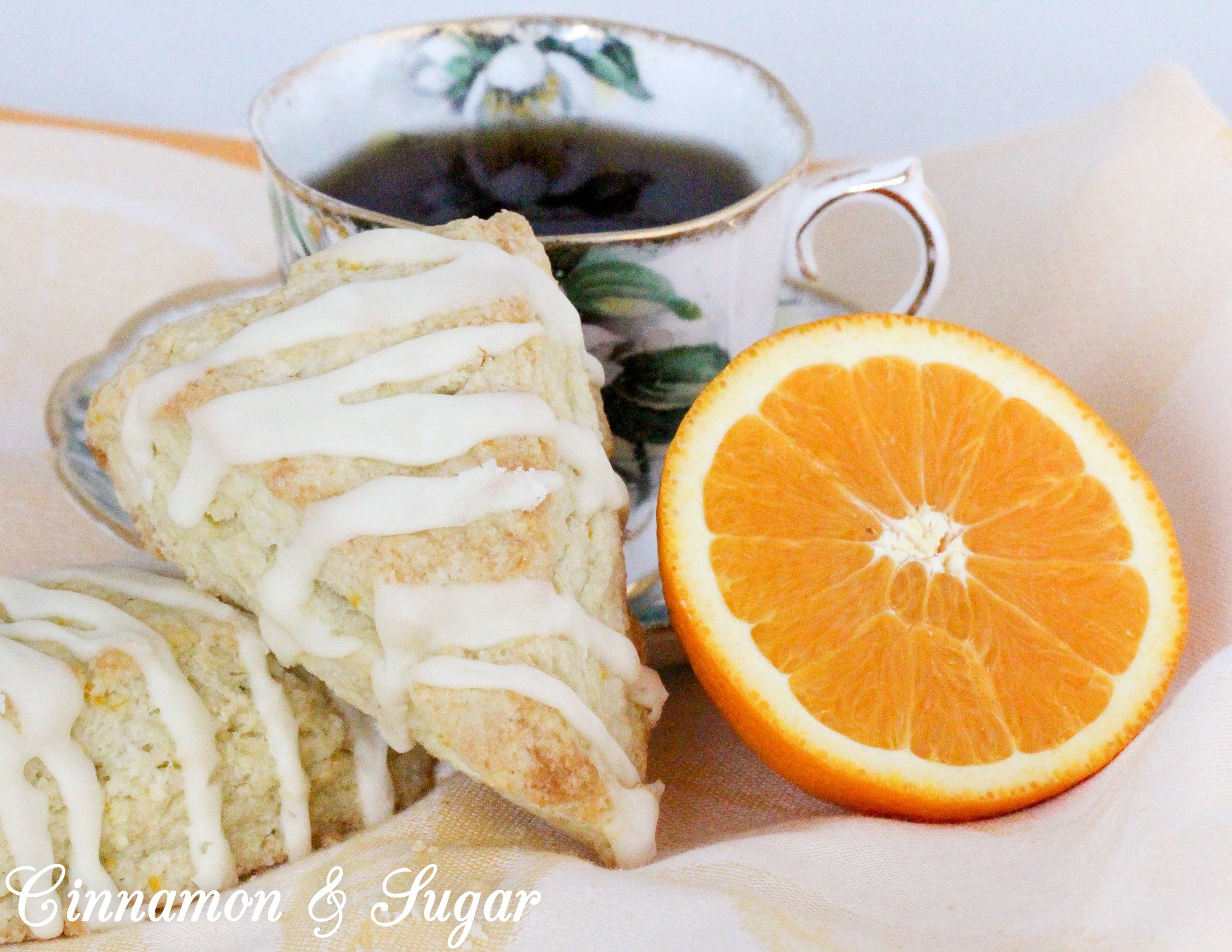 These flaky Orange Scones are easy to mix up and the sweet, orange glaze boosts the wow factor. Scrumptious on their own, a smear of orange marmalade would make them even more delectable! Recipe shared with permission granted by Maddie Day, author of NACHO AVERAGE MURDER. 