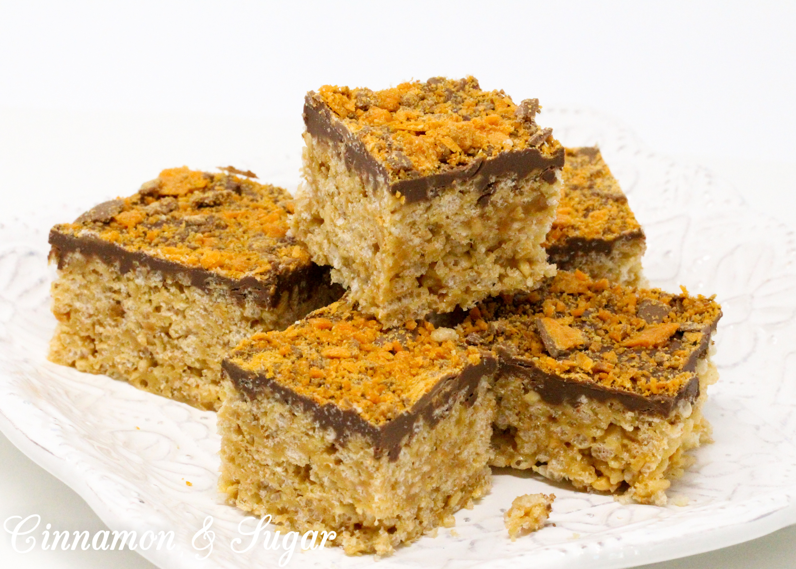A delicious riff on Rice Krispie Treats, Butterfinger Krispie Bars combines the flavors of the iconic candy bar: chocolate, butterscotch, and peanut butter! Recipe created by Cinnamon & Sugar for Deborah Garner, author of cozy mystery, A FLAIR FOR GOBLINS.