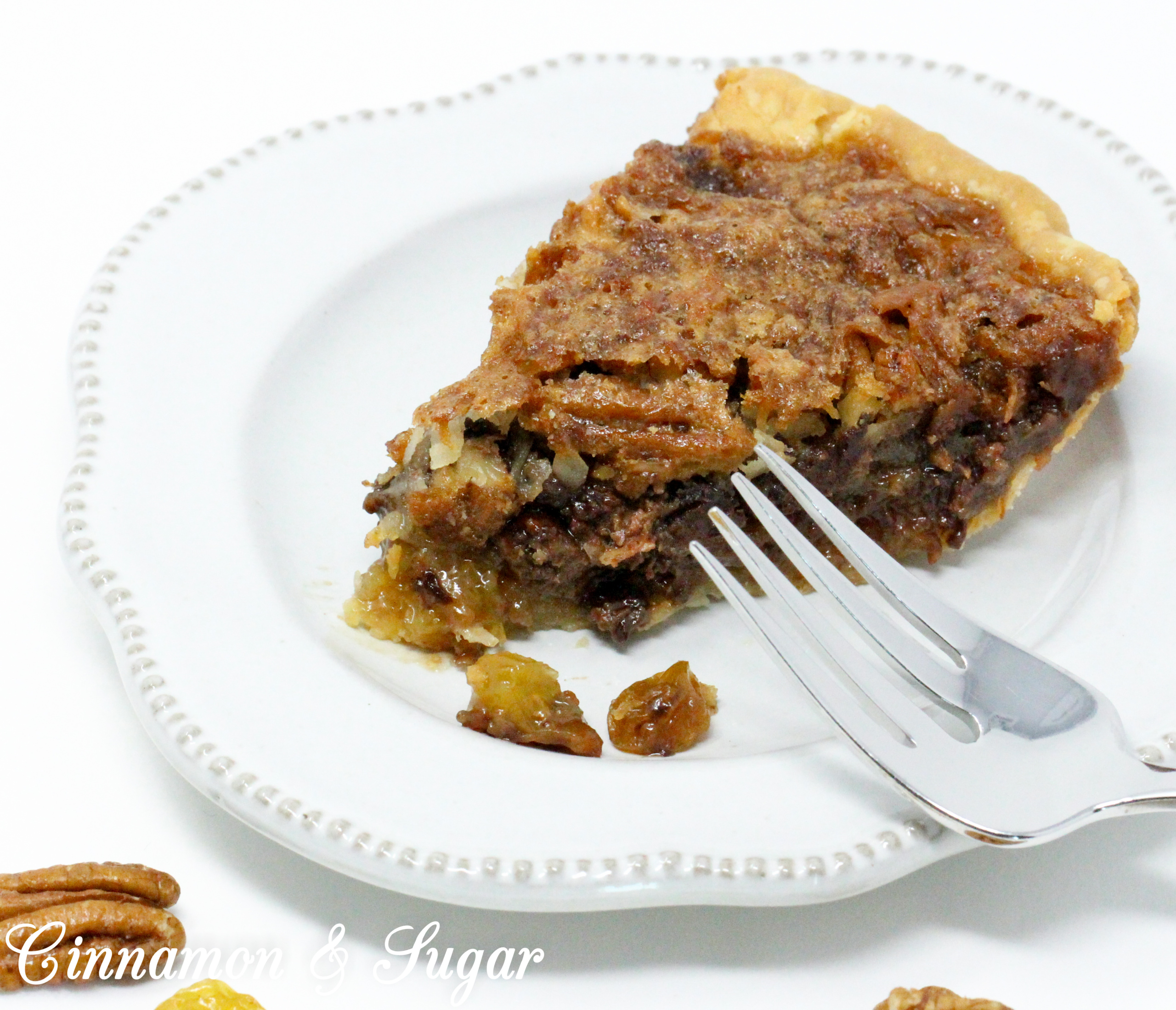 With a base similar to pecan pie, the addition of chocolate, raisins, and coconut raises the scrumptious level of Sugar High Pie to the stratosphere! Recipe shared with permission granted by Ellen Byron, author of MURDER IN THE BAYOU BONEYARD.