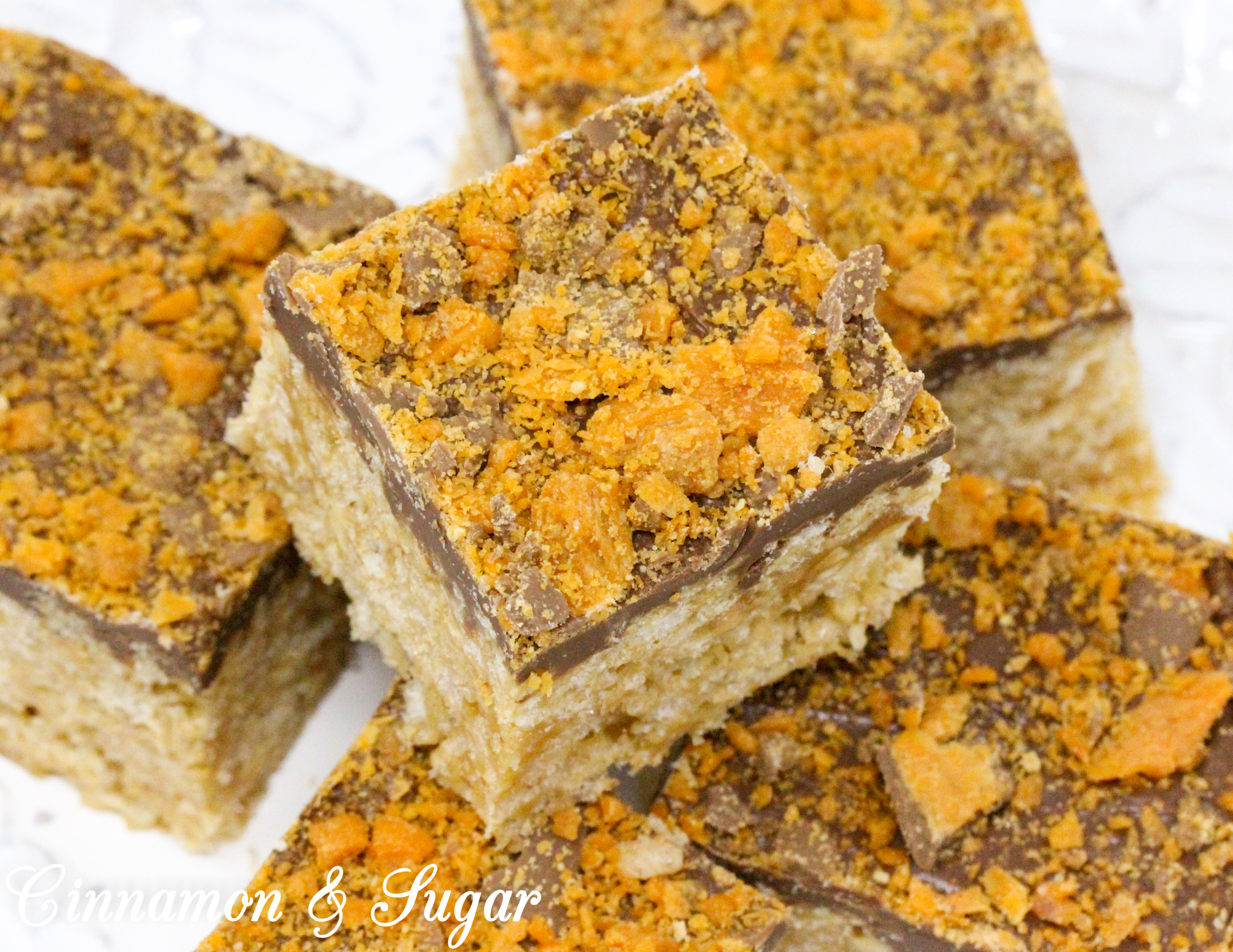 A delicious riff on Rice Krispie Treats, Butterfinger Krispie Bars combines the flavors of the iconic candy bar: chocolate, butterscotch, and peanut butter! Recipe created by Cinnamon & Sugar for Deborah Garner, author of cozy mystery, A FLAIR FOR GOBLINS.