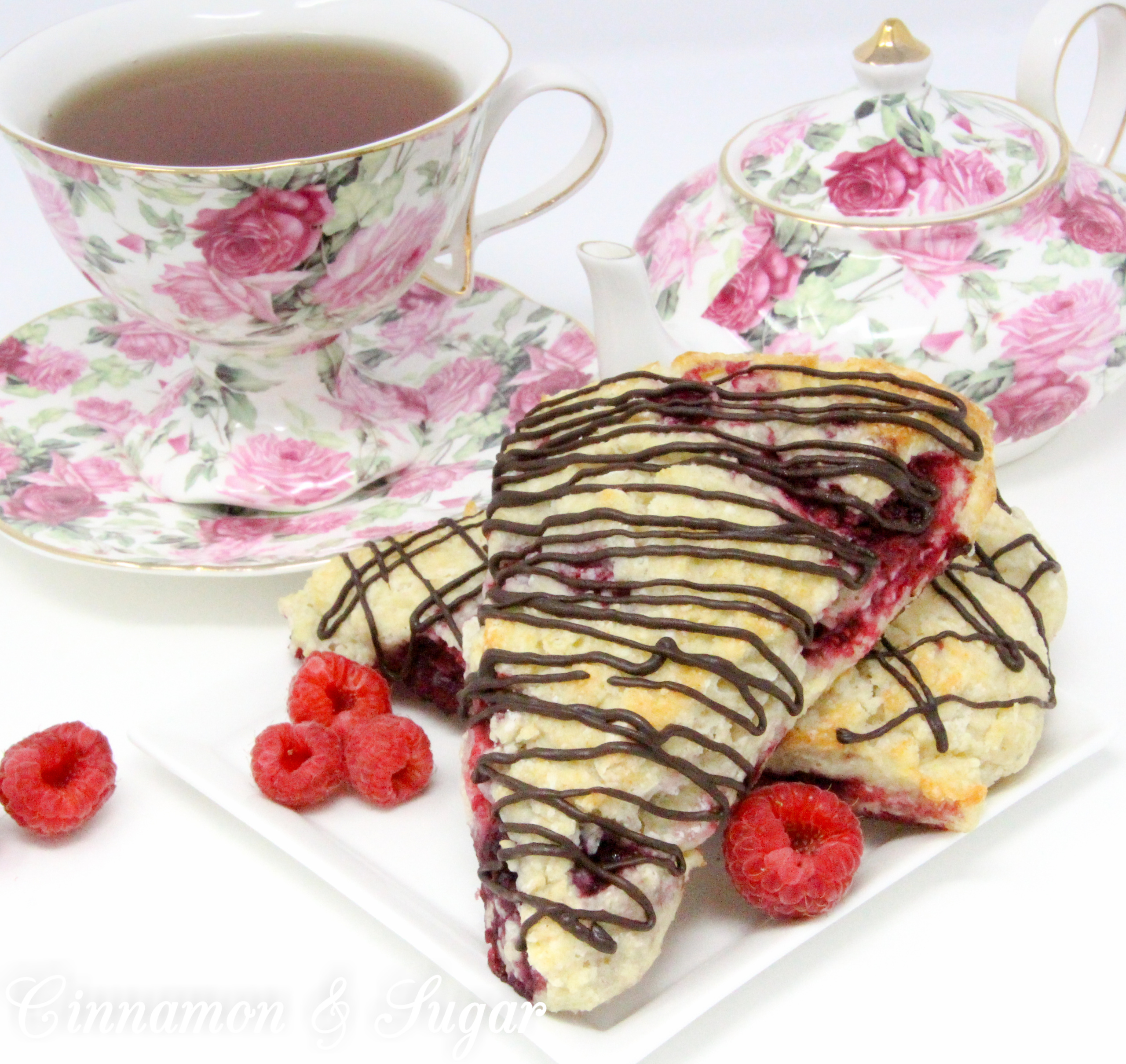 Raspberry Scones with Dark Chocolate Drizzle are rich, flaky, and flavorful, thanks to the addition of lemon oil and lemon peel, plus loads of raspberries. Drizzled with dark chocolate, the results are a scrumptious combination! 