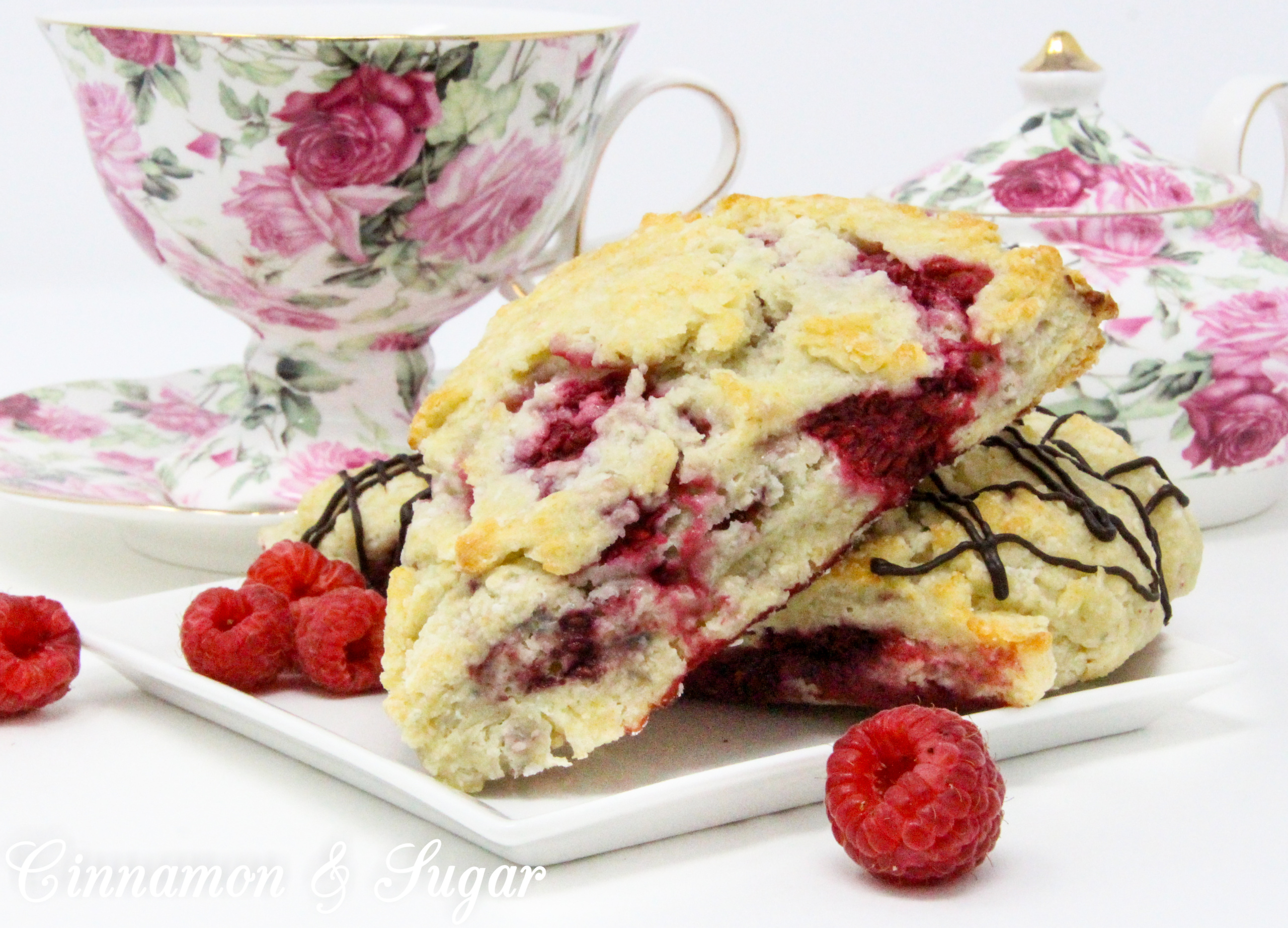 Raspberry Scones with Dark Chocolate Drizzle are rich, flaky, and flavorful, thanks to the addition of lemon oil and lemon peel, plus loads of raspberries. Drizzled with dark chocolate, the results are a scrumptious combination! 