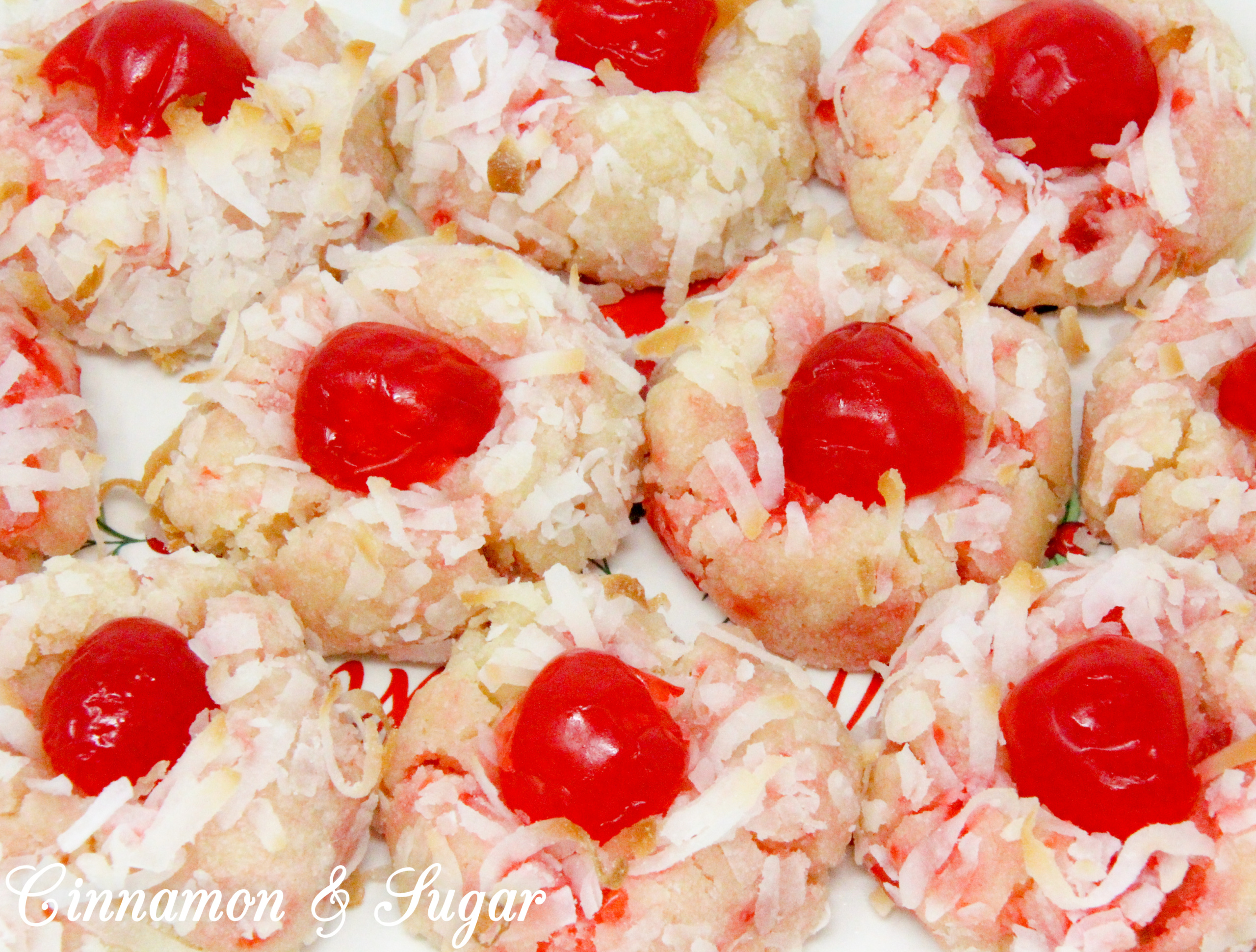 With snowy white coconut and glistening red cherries, shortbread-style Yuletide Coconut Cherry Cookies add holiday cheer to Christmas cookie platters. Recipe created by Cinnamon & Sugar for Deborah Garner, author of YULETIDE AT MOONGLOW. 