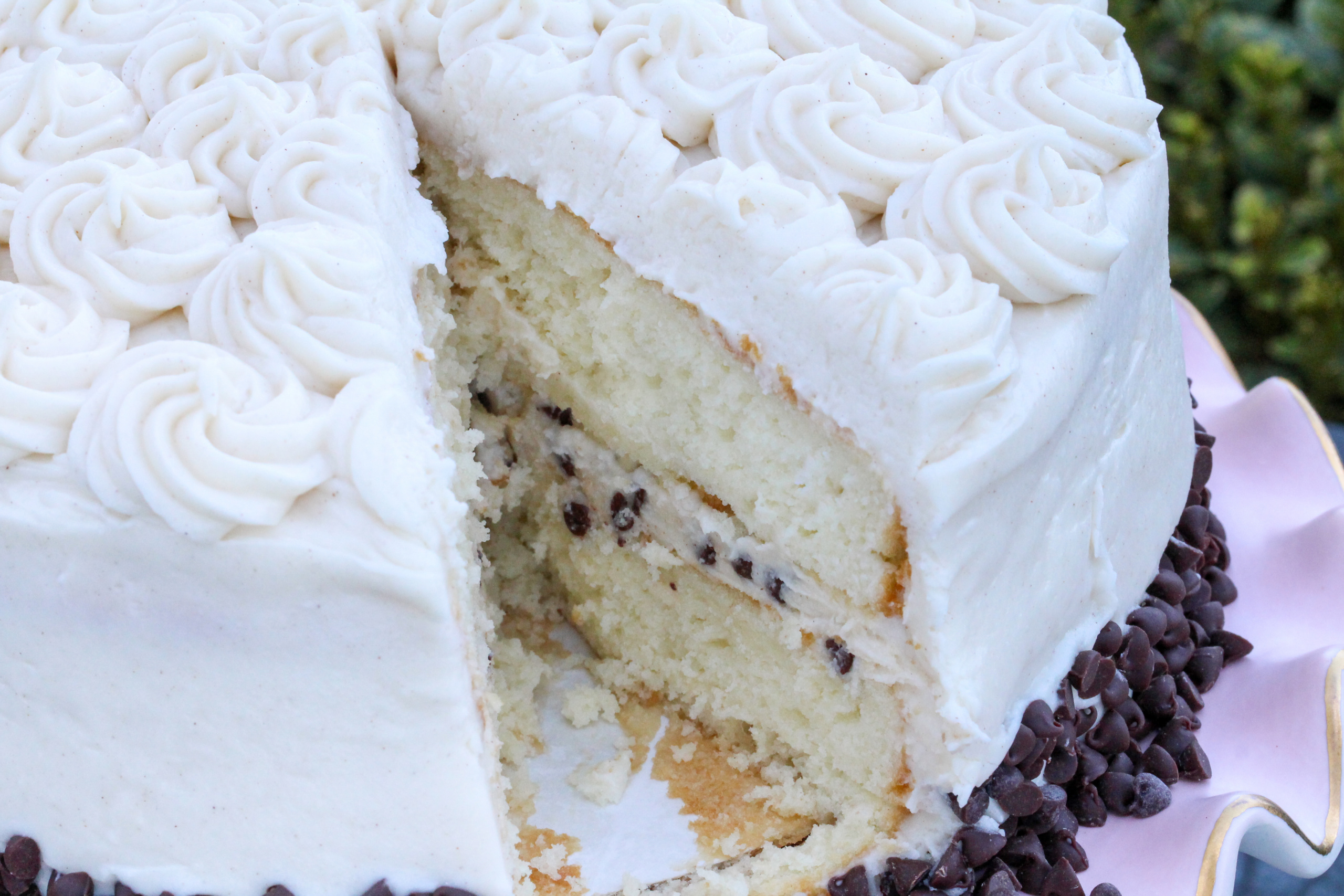 Cannoli Cake starts with a simple boxed cake mix but when paired with the combination of rich ricotta, mascarpone cheese, cream cheese, and chocolate chips in the luscious filling and frosting, the results are spectacularly decadent! Recipe shared with permission granted by Maria DiRico, author of LONG ISLAND ICED TINA. 
