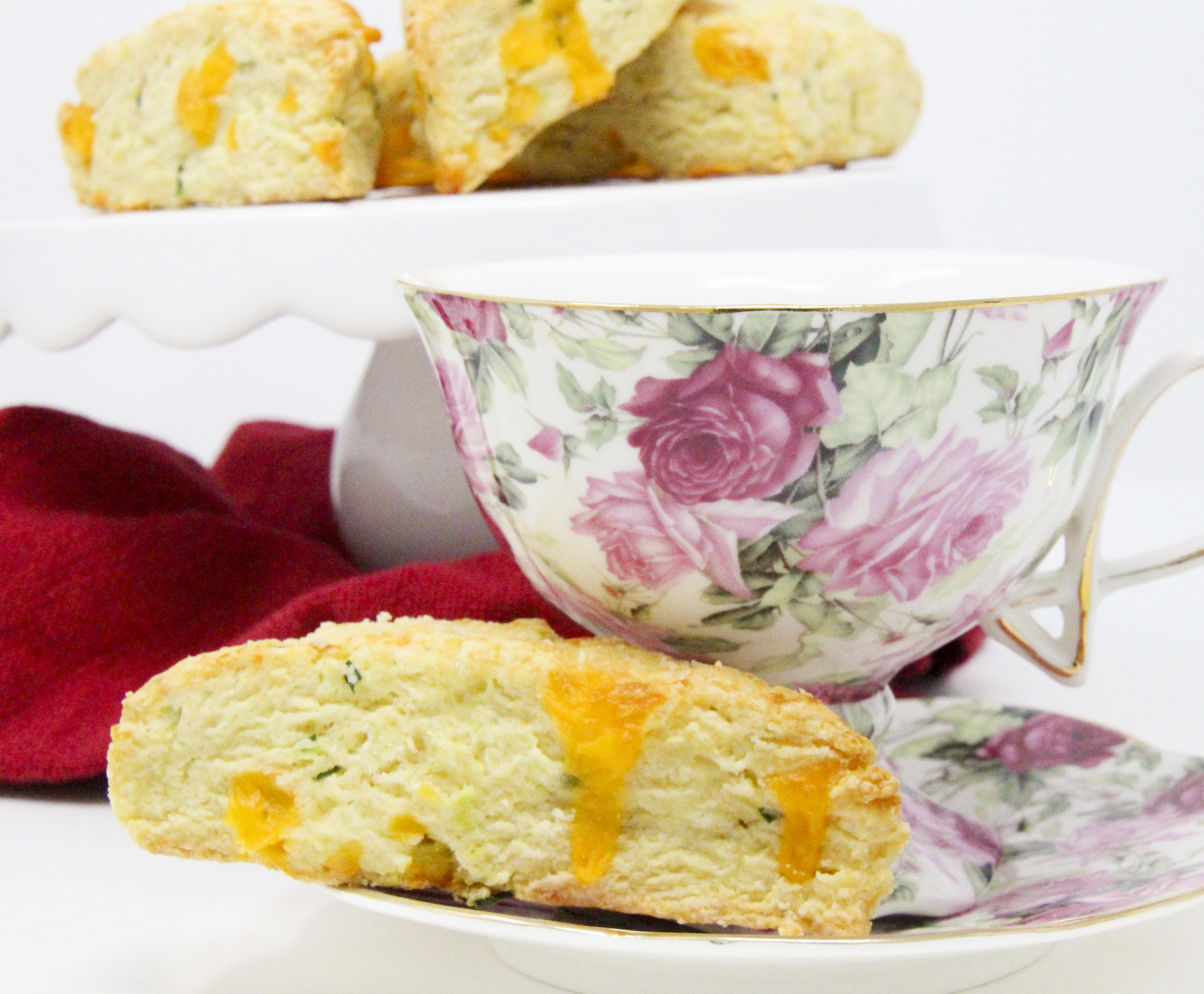 A delectable combination of flaky pastry, two kinds of cheese, and chives, Savory Cheese Scones are the perfect accompaniment to serve with a warming bowl of soup or even used as sandwich bread for lunch or a light supper. Recipe shared with permission granted by Kate Carlisle, author of LITTLE BLACK BOOK. 