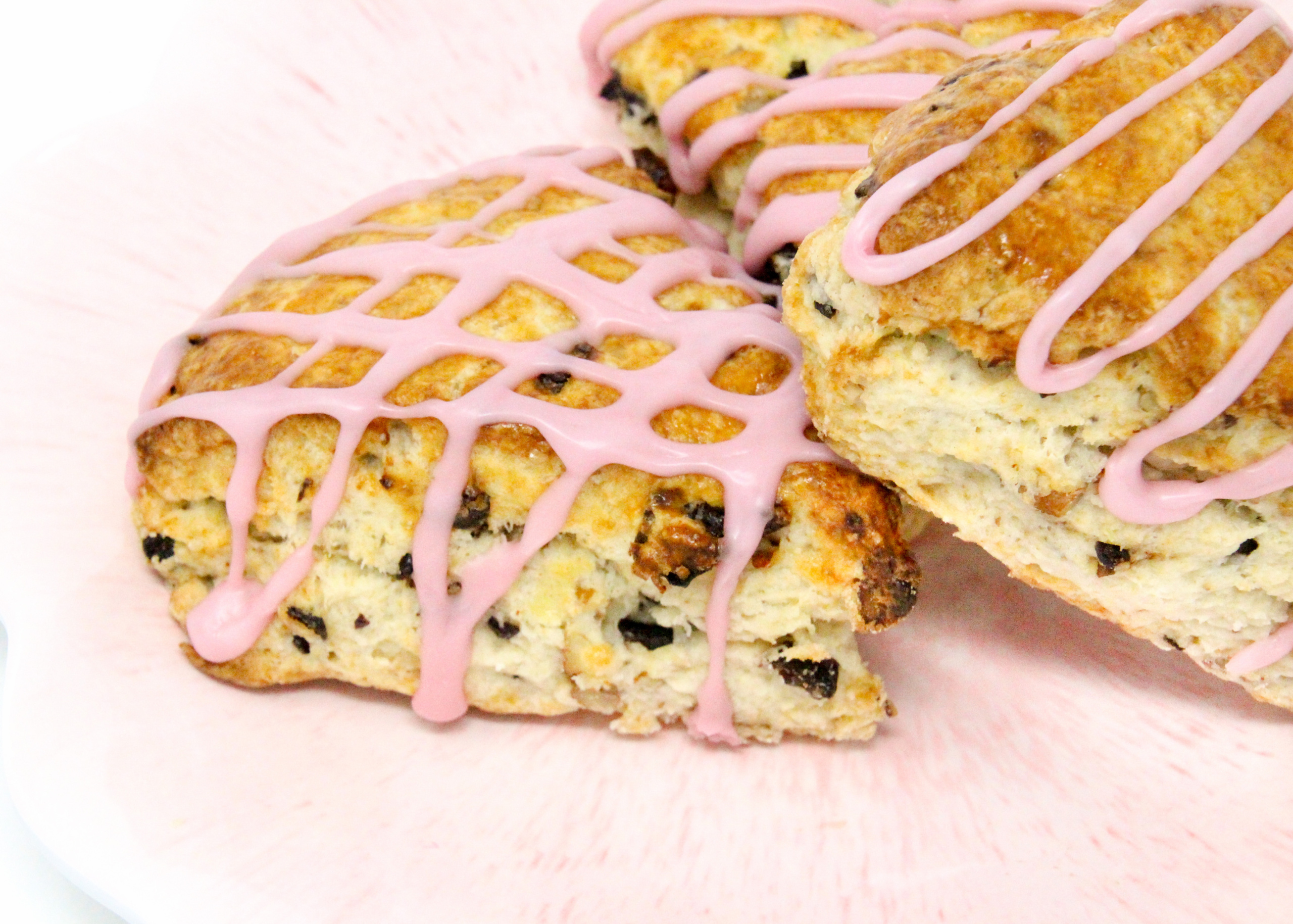 Whitney's Famous Cherry Scones are flaky pastry, studded with plump dried cherries and toasted pecans. A drizzle of cherry juice glaze makes these even more delicious. Recipe shared with permission granted by Darci Hannah, author of Cherry Scones & Broken Bones. 