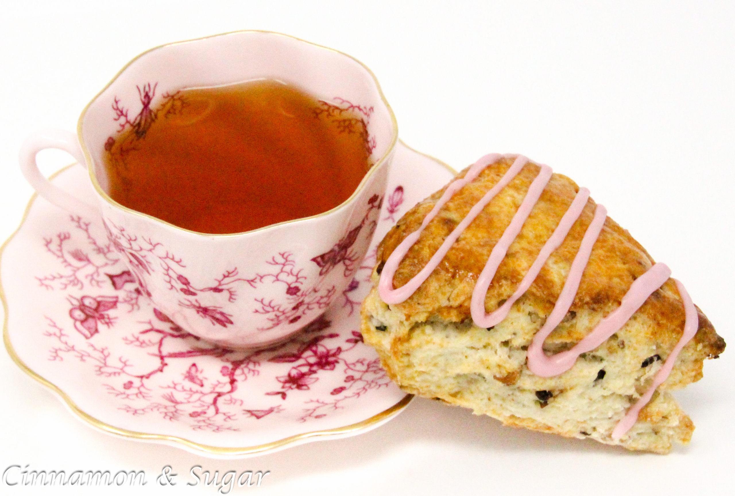 Whitney's Famous Cherry Scones are flaky pastry, studded with plump dried cherries and toasted pecans. A drizzle of cherry juice glaze makes these even more delicious. Recipe shared with permission granted by Darci Hannah, author of Cherry Scones & Broken Bones. 