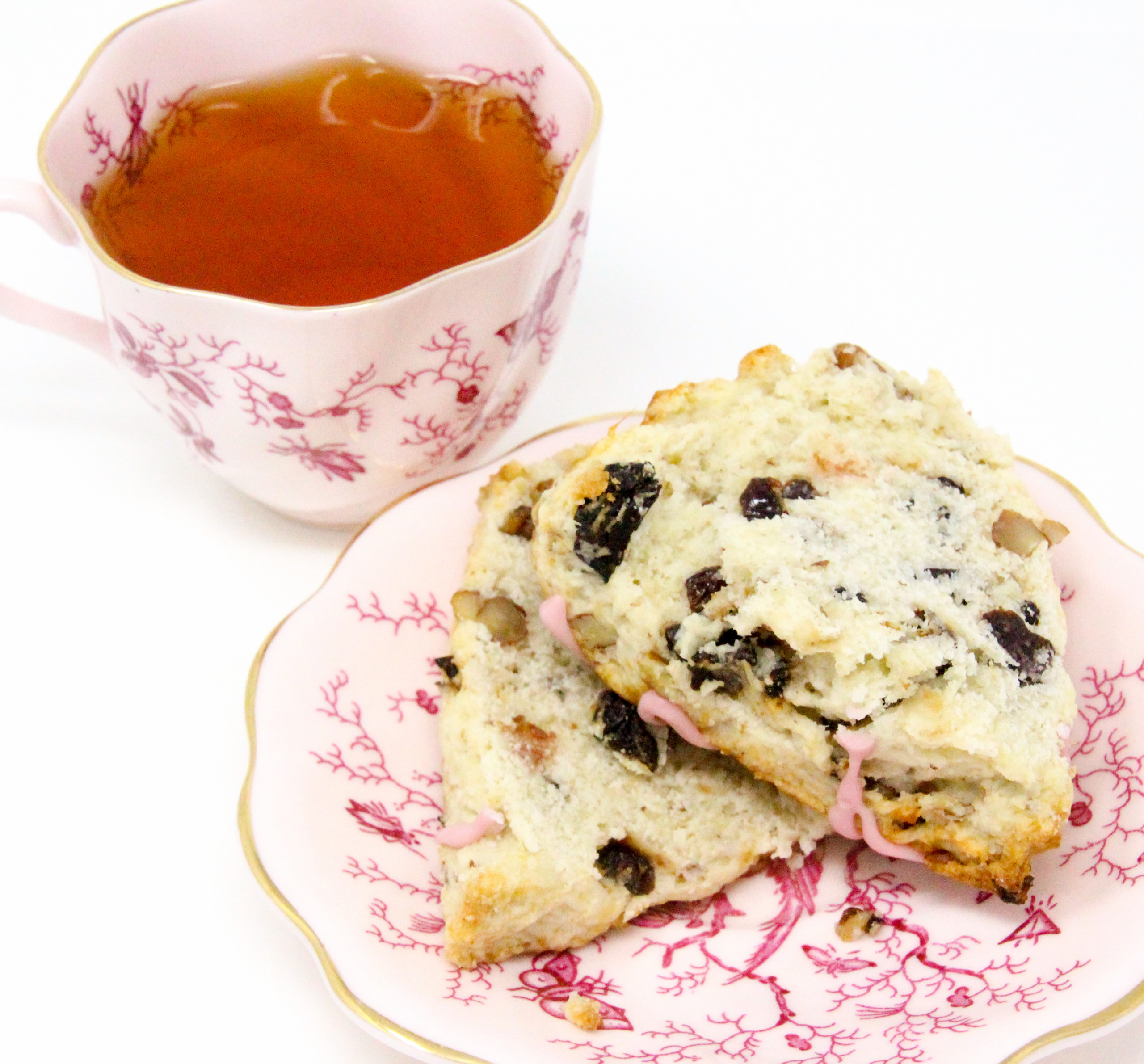 Whitney's Famous Cherry Scones are flaky pastry, studded with plump dried cherries and toasted pecans. A drizzle of cherry juice glaze makes these even more delicious. Recipe shared with permission granted by Darci Hannah, author of Cherry Scones & Broken Bones. 