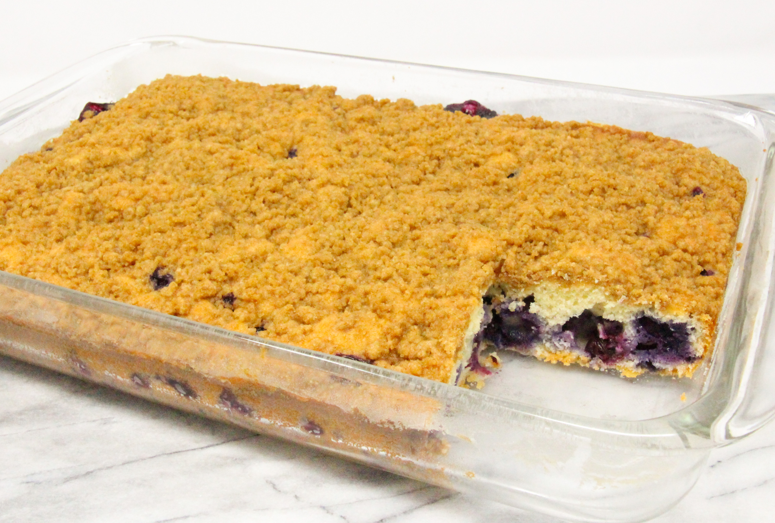 Blueberry Coffee Cake with Crumble is chock full of fresh blueberries in a tender vanilla cake. The cinnamon, brown sugar-based crumble adds both flavor and a pleasing crunchy texture. Recipe shared with permission granted by Krista Davis, author of A COLORFUL SCHEME. 