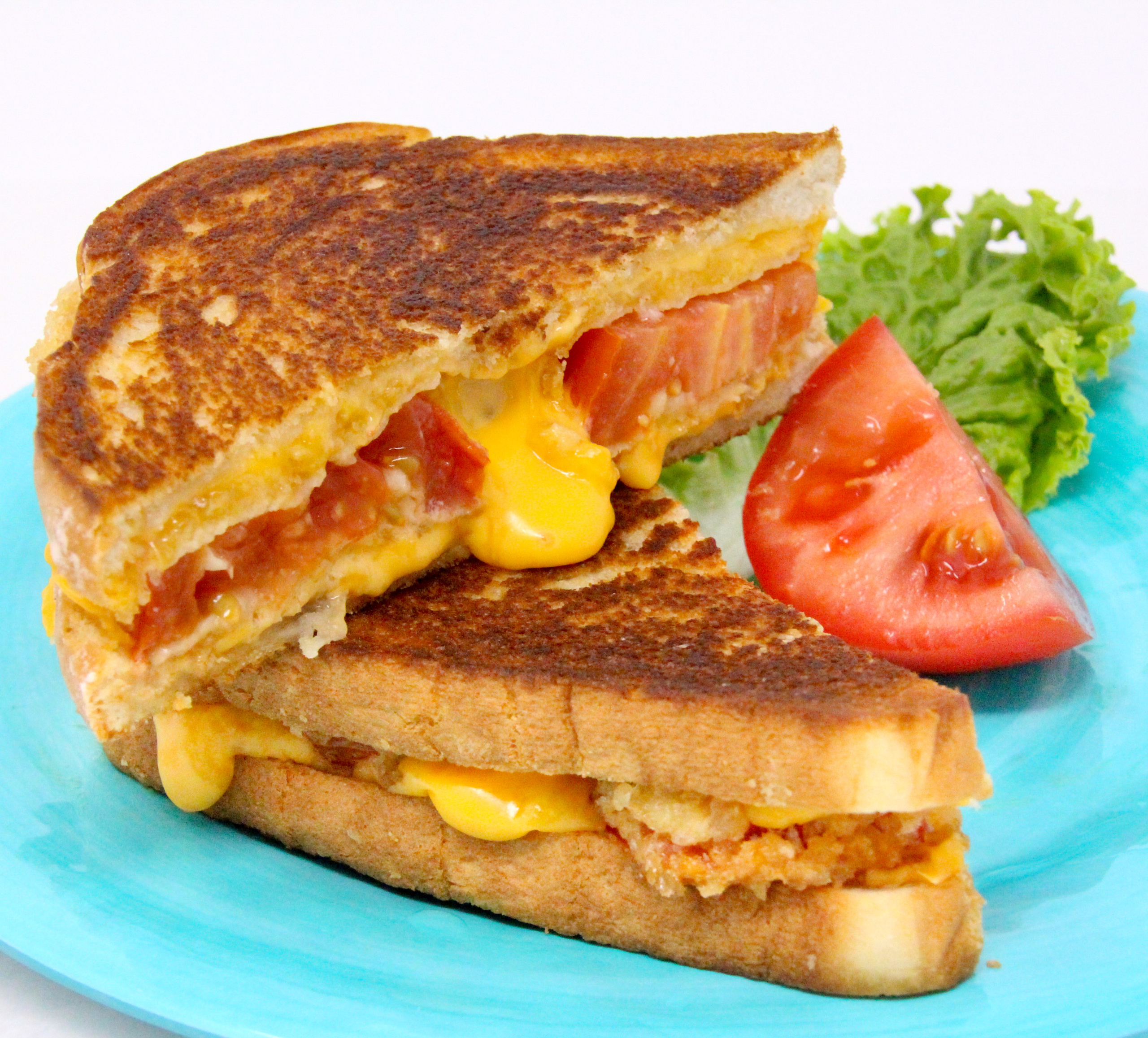 Alvin’s Panko Perfection grilled cheese sandwich features sun-ripened tomatoes coated with crunchy panko, tangy Parmesan, and oozing, melted sharp cheddar cheese. Recipe shared with permission granted by Linda Reilly, author of NO PARM NO FOUL.