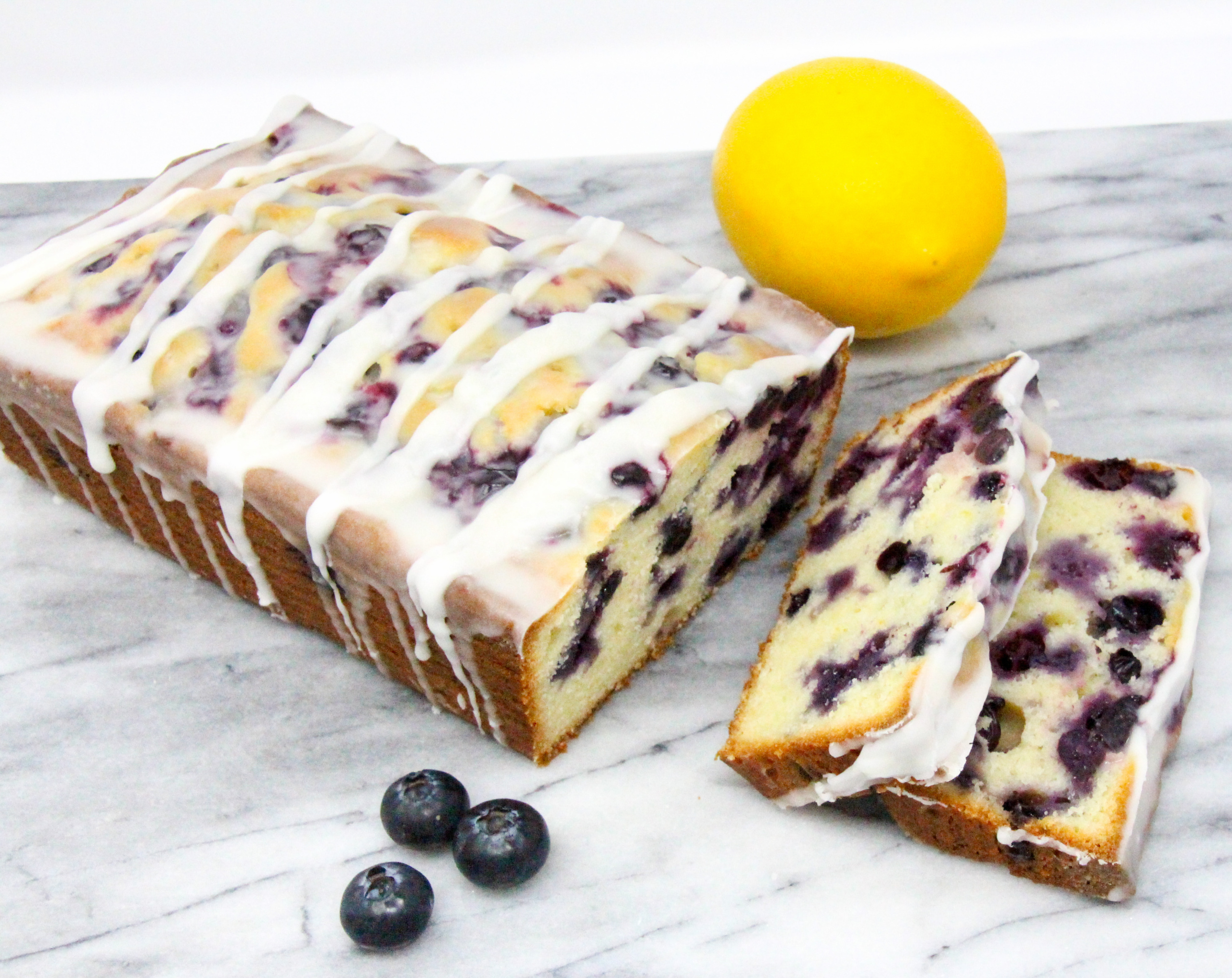 Blueberry Lemon Bread is a delectable tender and moist bread with plump juicy blueberries studded throughout and a sweet-tart lemony glaze. Recipe shared with permission granted by Darci Hannah, author of MURDER AT THE BLUEBERRY FESTIVAL. 