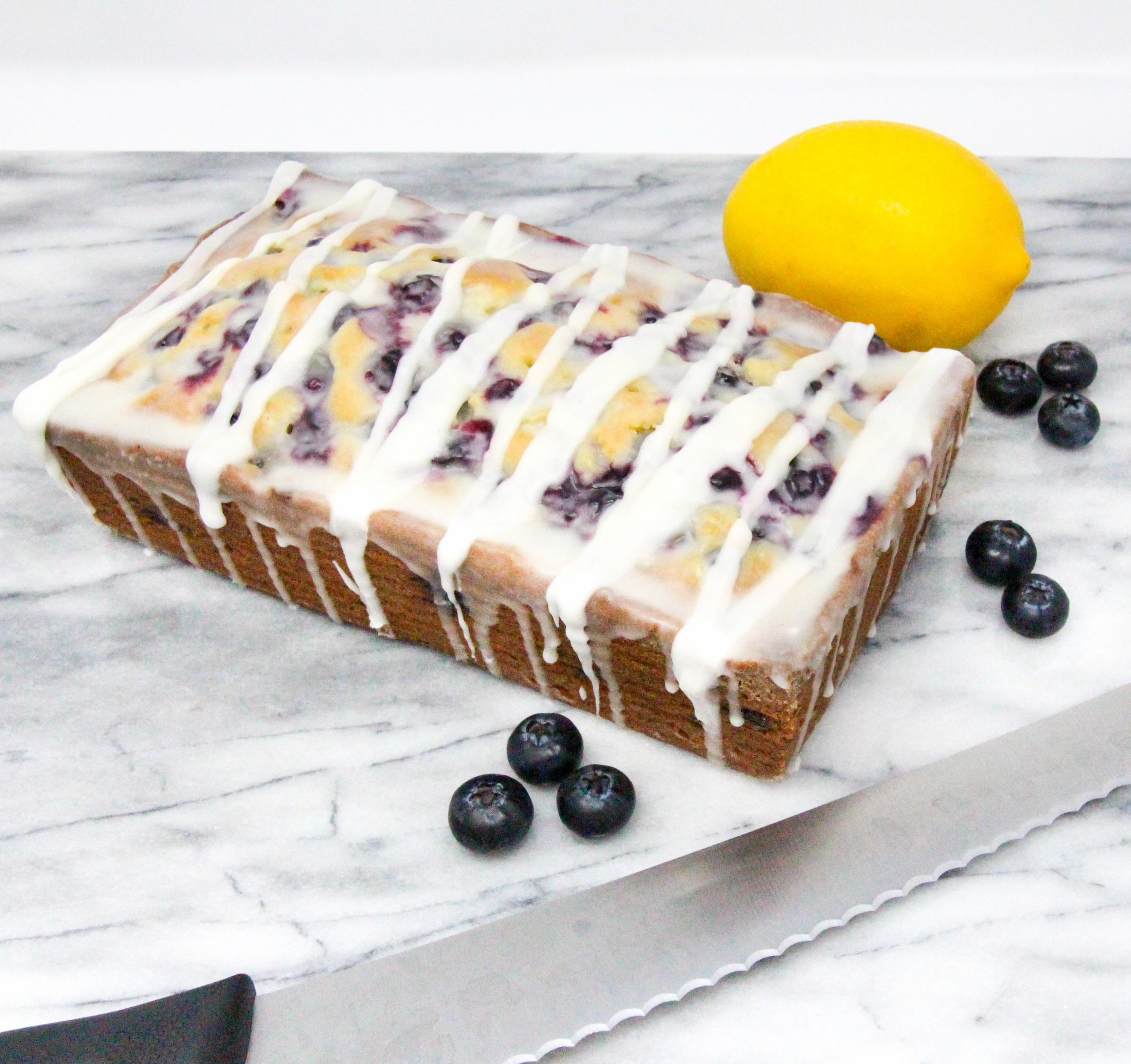 Blueberry Lemon Bread is a delectable tender and moist bread with plump juicy blueberries studded throughout and a sweet-tart lemony glaze. Recipe shared with permission granted by Darci Hannah, author of MURDER AT THE BLUEBERRY FESTIVAL. 