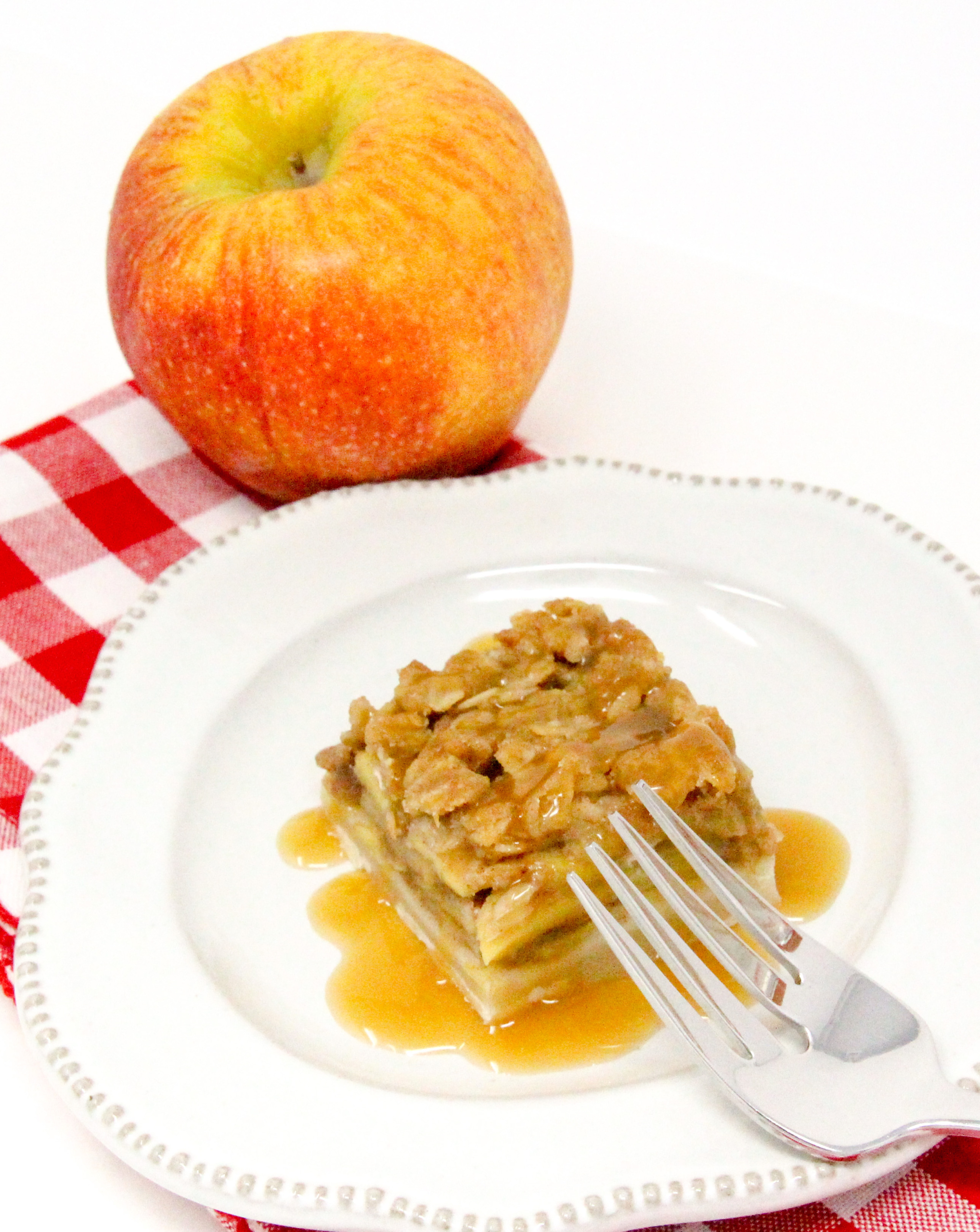 With a pastry base, a filling of spiced apples, and a crunchy oat topping, Caramel Apple Pie Bars are a delicious taste of autumn! Recipe from BUTTERCREAM BETRAYAL by Kim Davis. 