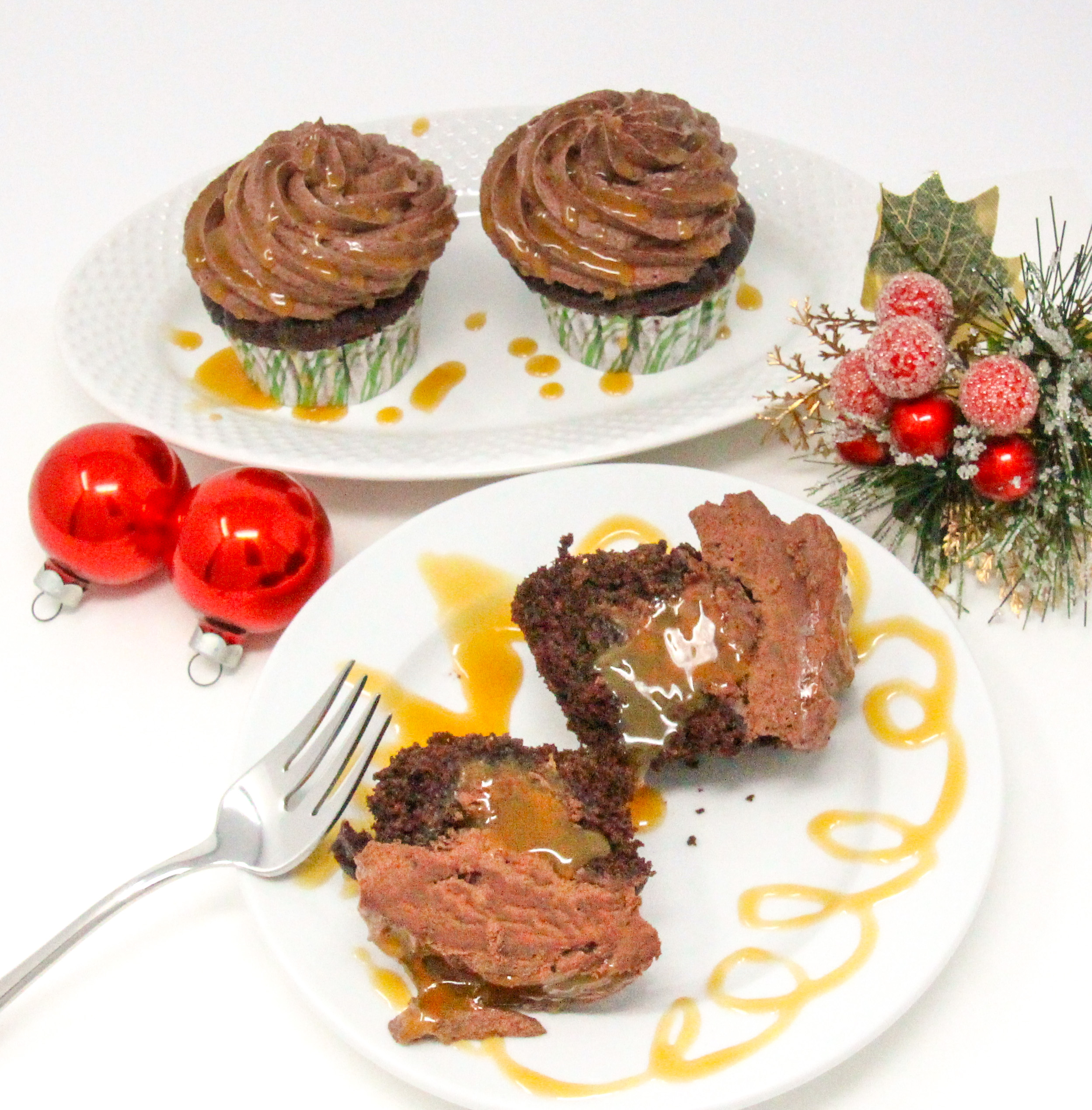 Christmas Caramel Cupcakes are rich, dark chocolate cupcakes, stuffed with homemade caramel, then topped with fudgy buttercream frosting and more caramel! Recipe shared with permission granted by Christina Romeril, author of A CHRISTMAS CANDY KILLING.