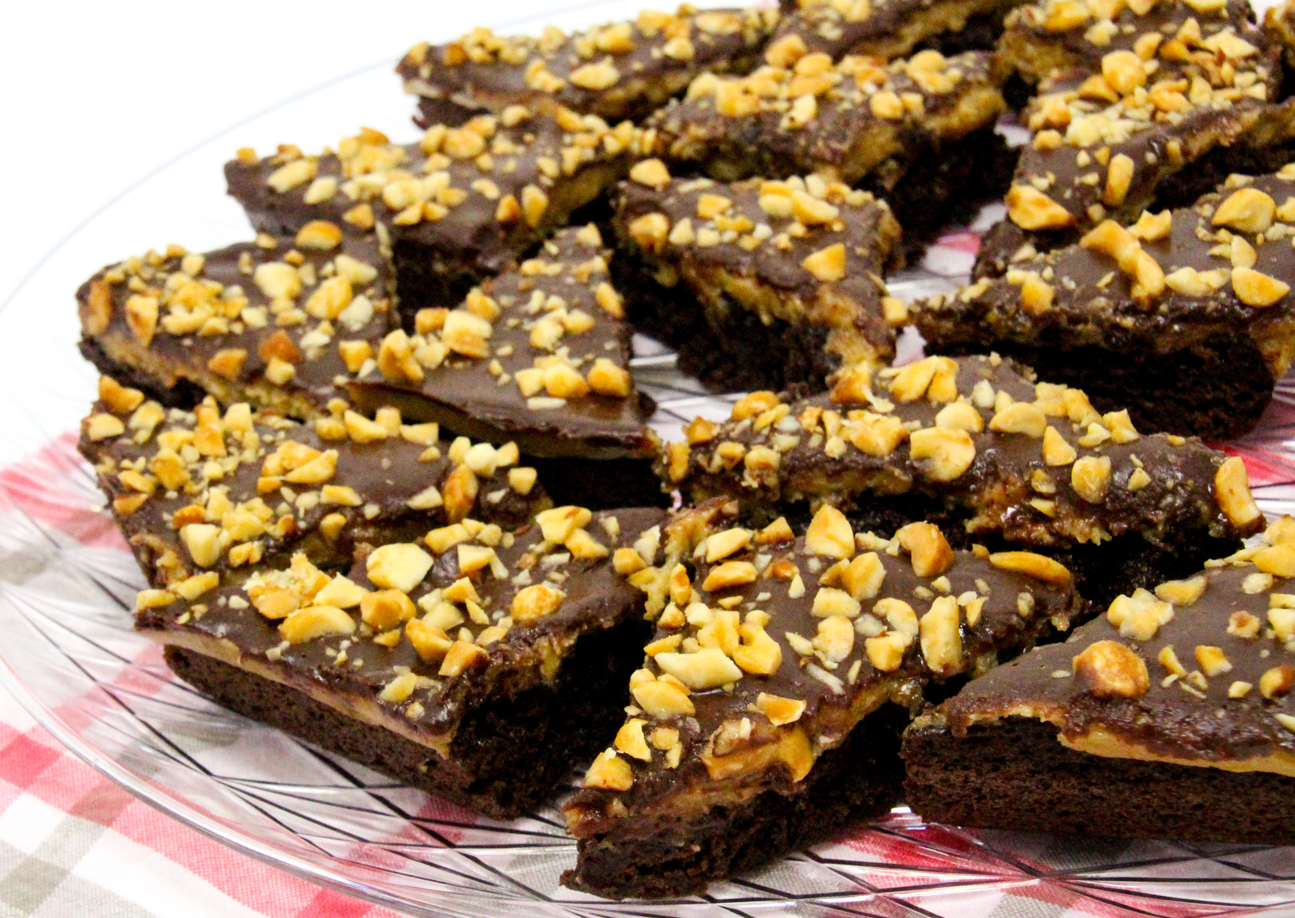 Triple-Layer Peanut Butter Brownies feature a creamy peanut butter filling spread over brownies and then topped with rich chocolate and sprinkled with peanuts. This swoon-worthy concoction makes a large amount to share, which is sure to earn you brownie points from your family and friends! Recipe shared with permission granted by Heather Weidner, author of FILM CREWS AND RENDEZVOUS. 