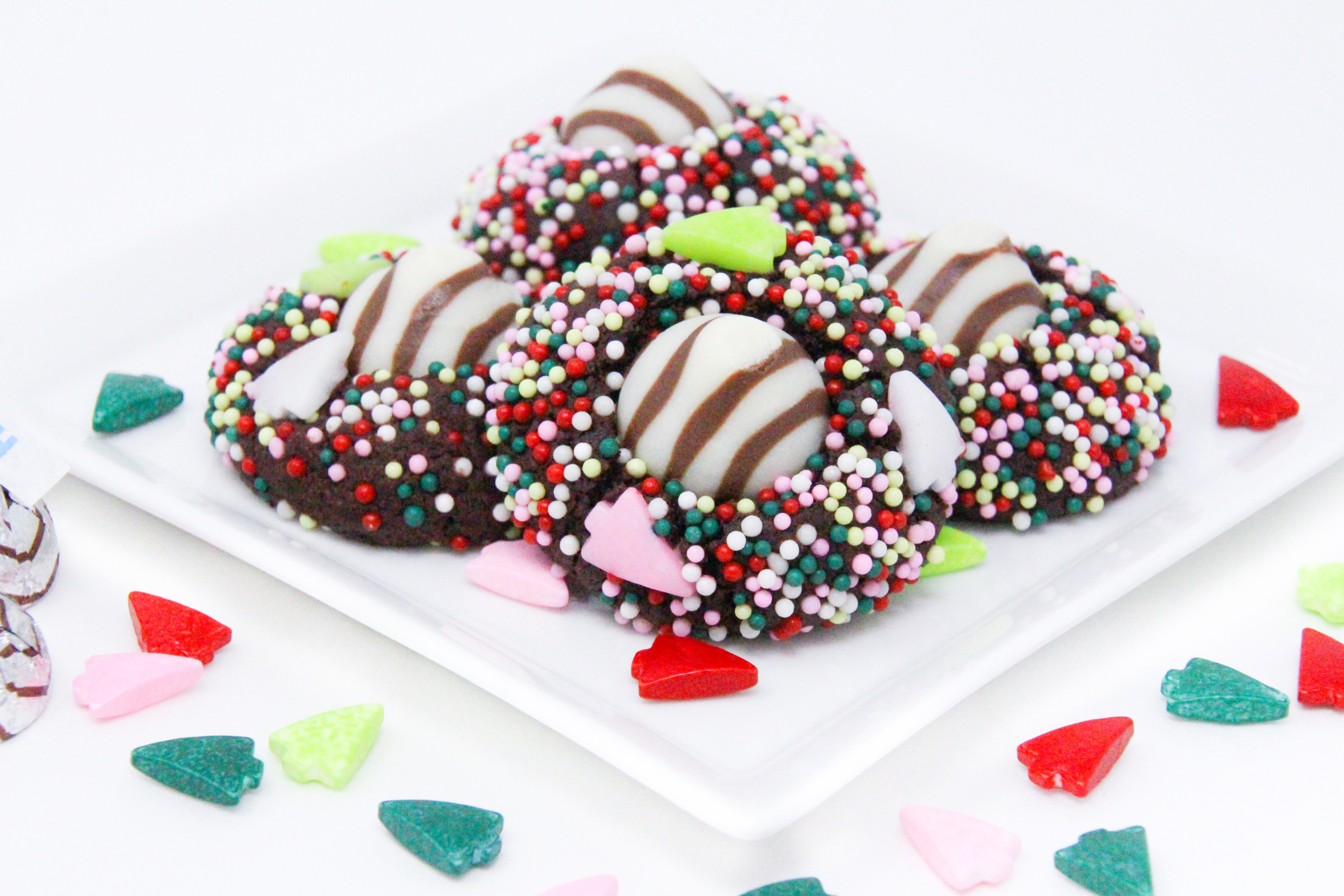 Christmas Hugs & Kisses Cookies have a chocolate base with a hint of peppermint. Rolled in colorful holiday sprinkles before baking then topped with a Hershey’s Hug or Kiss for an extra bite of chocolate will have Santa linger hearthside to finish a plate of these festive cookies! Recipe created by Cinnamon & Sugar for Deborah Garner, author of JOY AT MOONGLOW. 