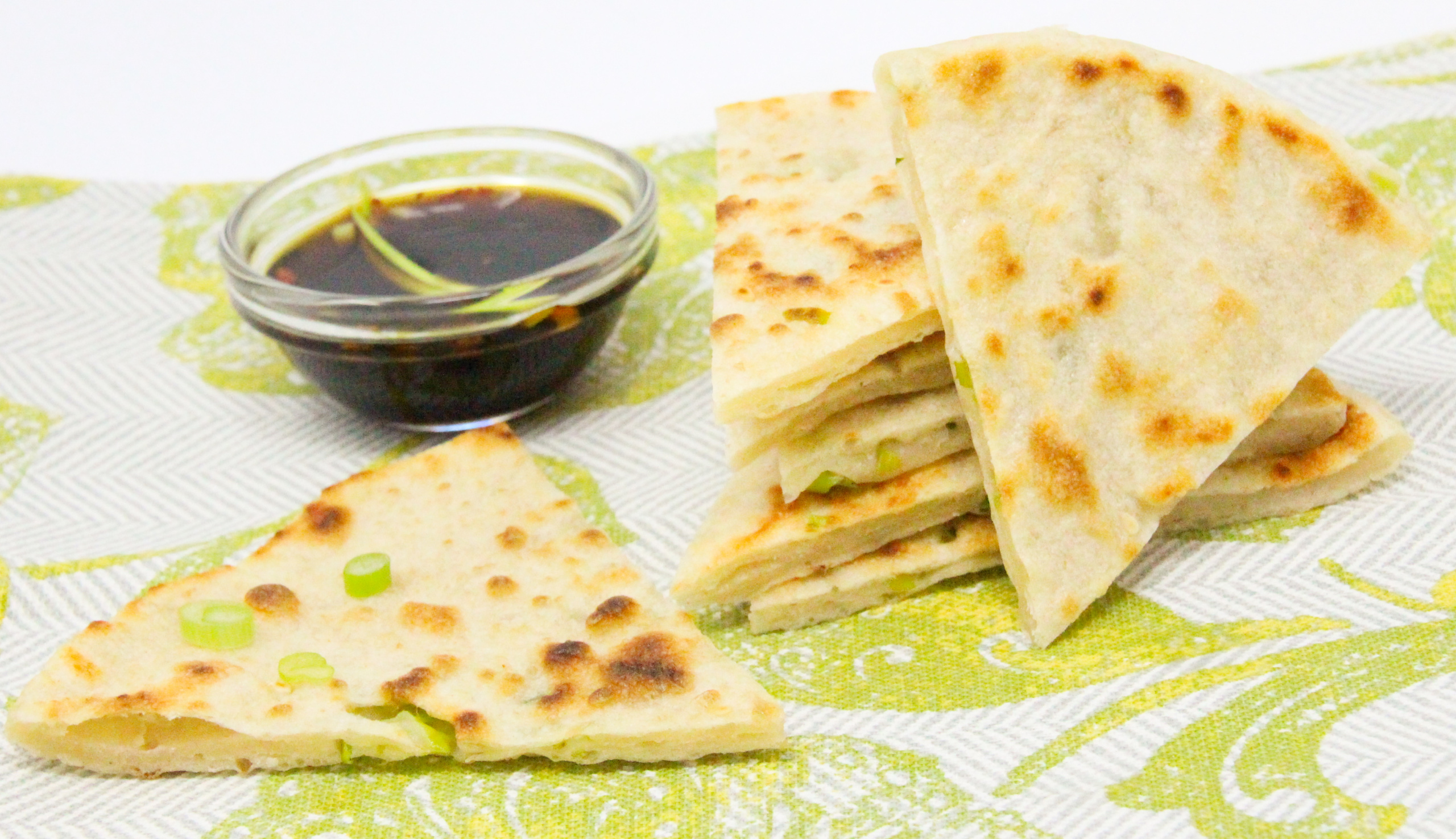 A few super simple ingredients and a hot skillet are all that's necessary to whip up delicious Scallion Pancakes. Recipe shared with permission granted by Jennifer J. Chow, author of HOT POT MURDER. 