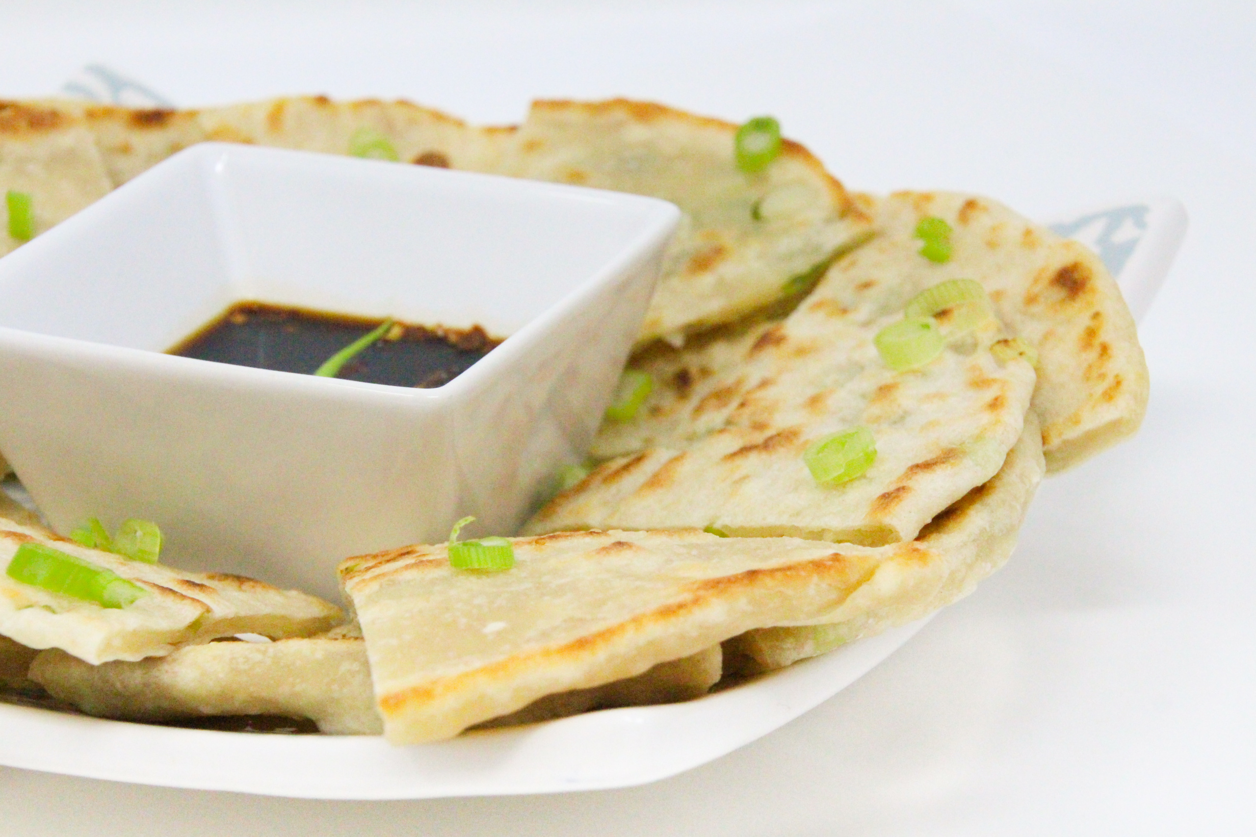 A few super simple ingredients and a hot skillet are all that's necessary to whip up delicious Scallion Pancakes. Recipe shared with permission granted by Jennifer J. Chow, author of HOT POT MURDER. 