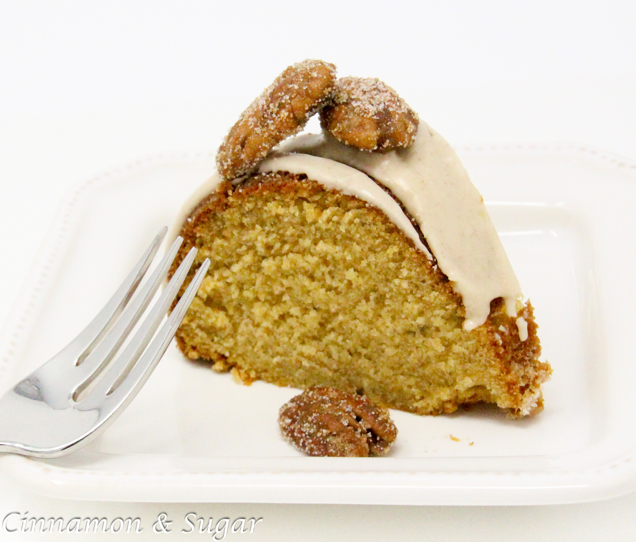 Maple Bundt cake with maple cinnamon glaze and candied pecans is a moist cake with caramel-y maple flavor. Paired with maple cinnamon glaze and candied pecans, this dessert becomes company-worthy! Recipe created by Cinnamon & Sugar for Catherine Bruns, author of SYRUP TO NO GOOD. 