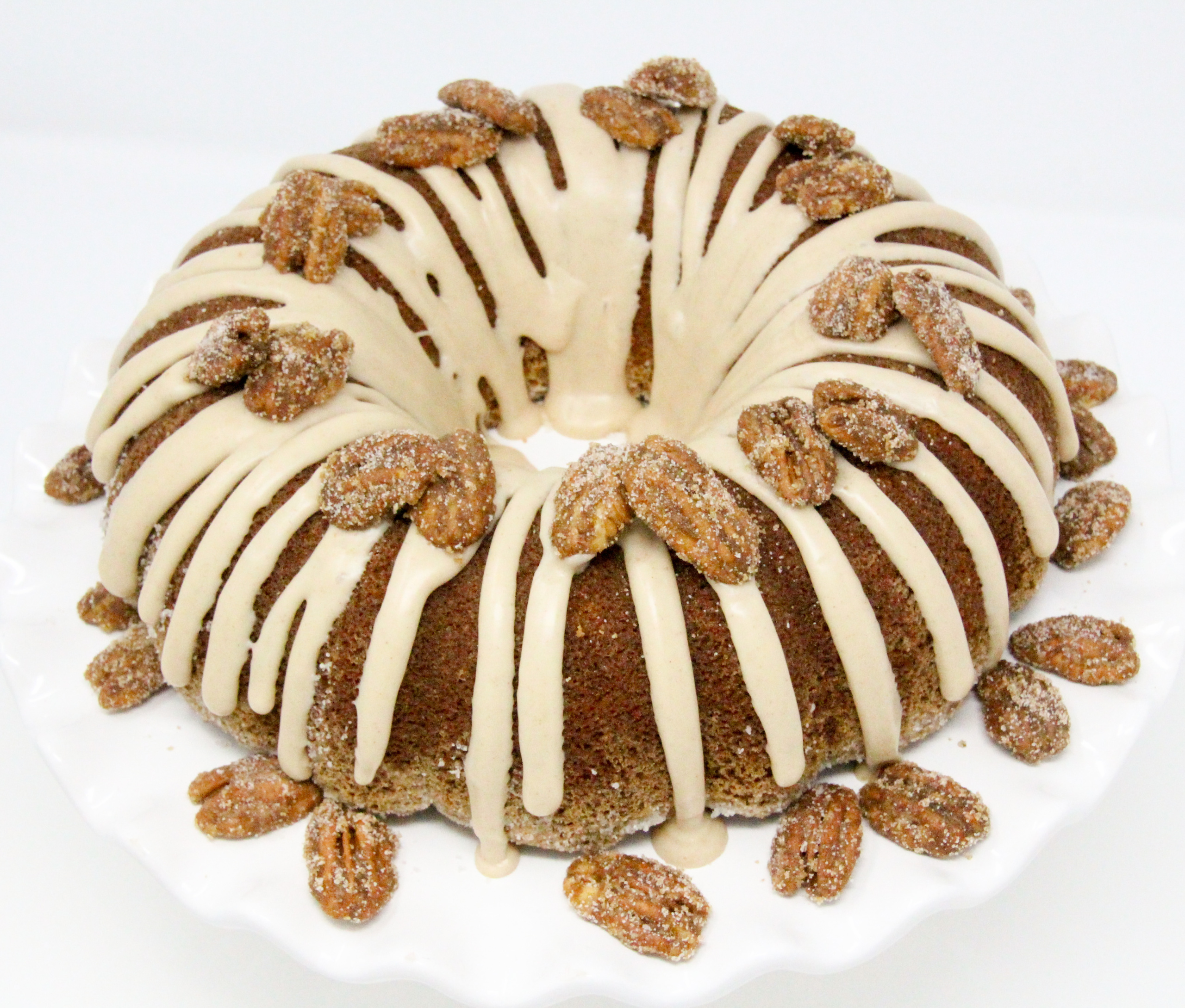 Maple Bundt cake with maple cinnamon glaze and candied pecans is a moist cake with caramel-y maple flavor. Paired with maple cinnamon glaze and candied pecans, this dessert becomes company-worthy! Recipe created by Cinnamon & Sugar for Catherine Bruns, author of SYRUP TO NO GOOD. 