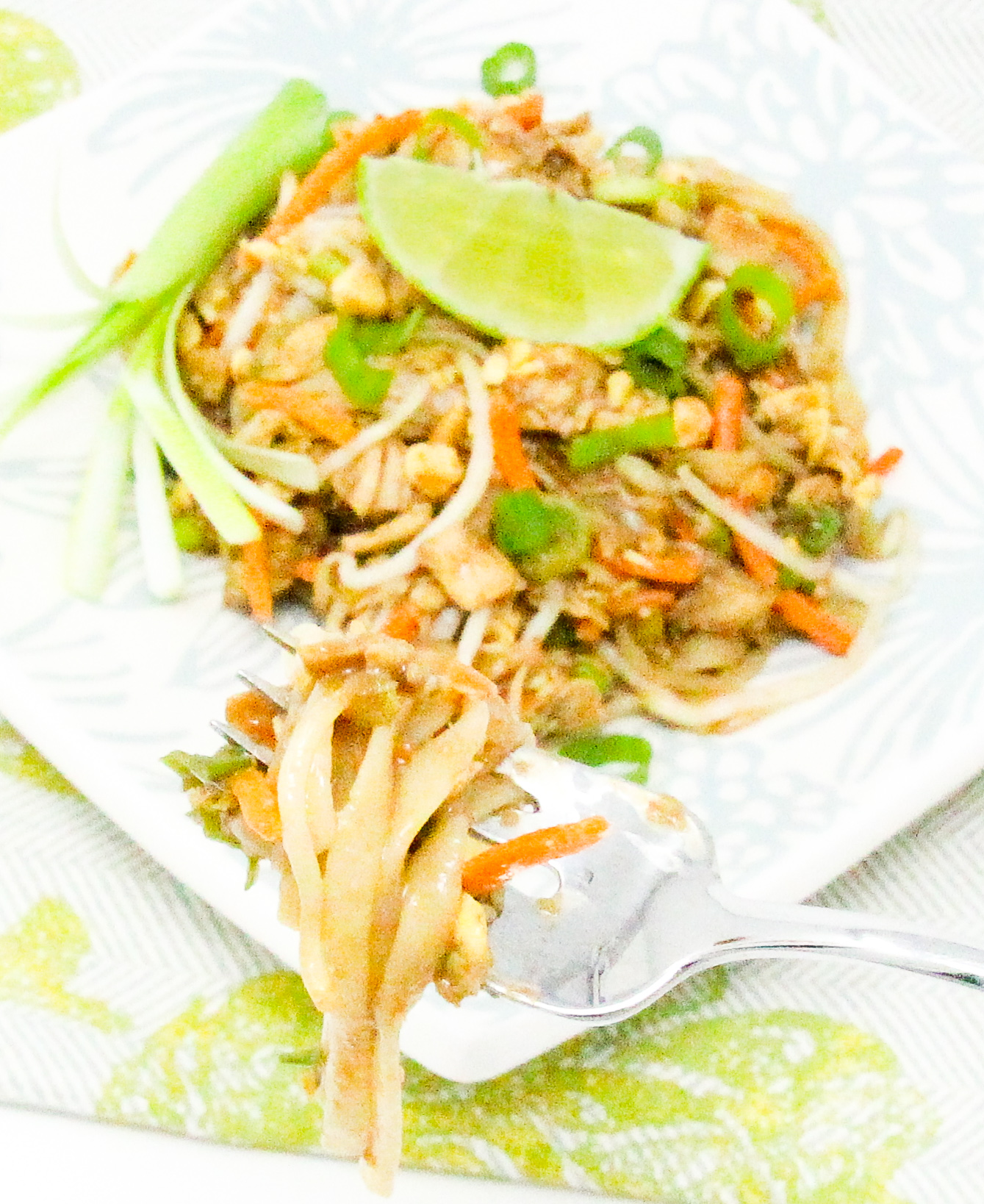 Chicken Pad Thai combines a spicy sweet sauce with rice noodles (making this dish naturally gluten-free), while the crunch of the veggies and roasted peanuts add a pleasing texture. Recipe shared with permission granted by Maddie Day, author of MURDER AT THE RUSTY ANCHOR. 