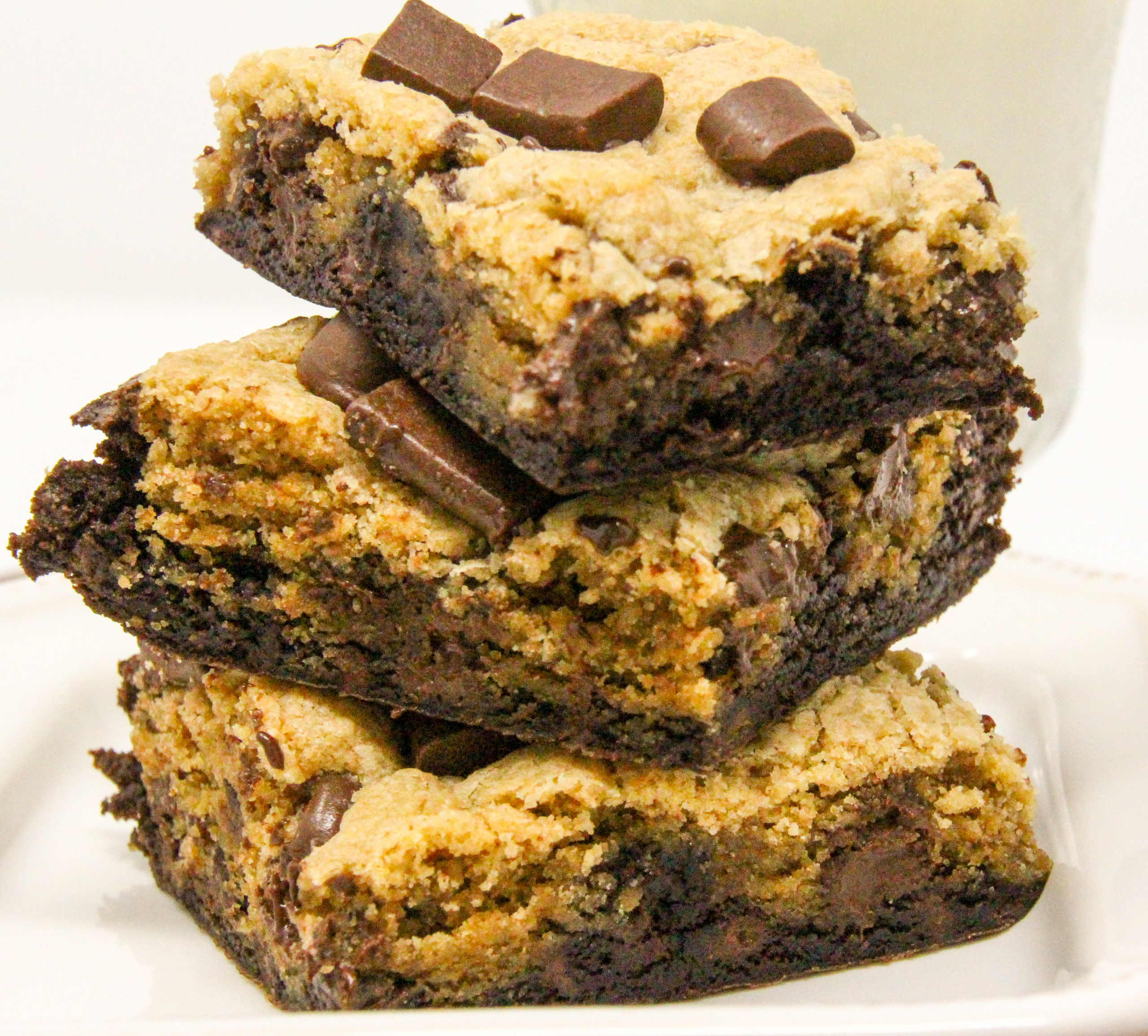 Brookies are a combination of rich, chocolatey brownies topped with chocolate chip cookie dough and garnished with dark chocolate chunks. Pure yumminess in one bar! Recipe created by Cinnamon & Sugar for Ellen Byron, author of A VERY WOODSY MURDER.