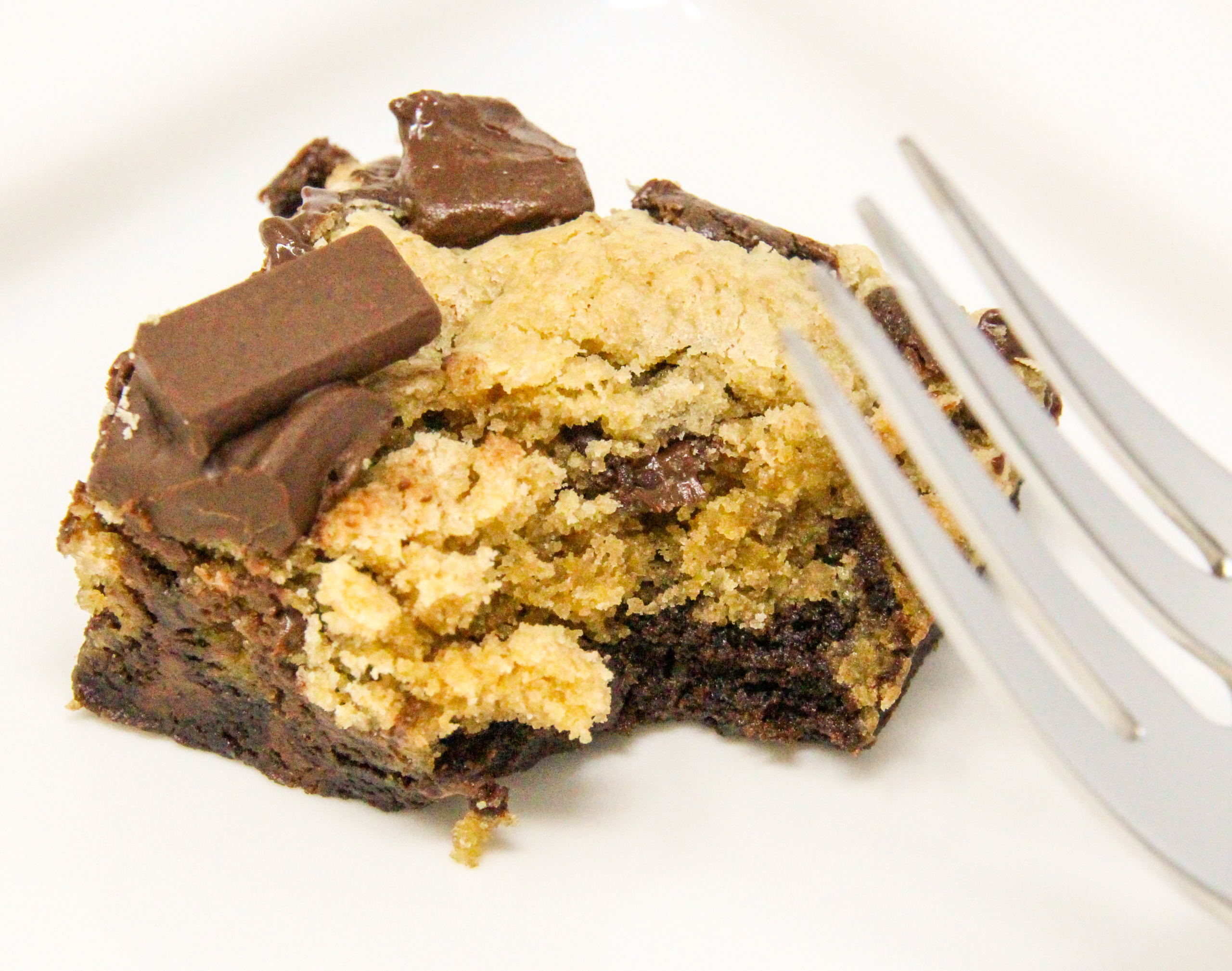 Brookies are a combination of rich, chocolatey brownies topped with chocolate chip cookie dough and garnished with dark chocolate chunks. Pure yumminess in one bar! Recipe created by Cinnamon & Sugar for Ellen Byron, author of A VERY WOODSY MURDER.