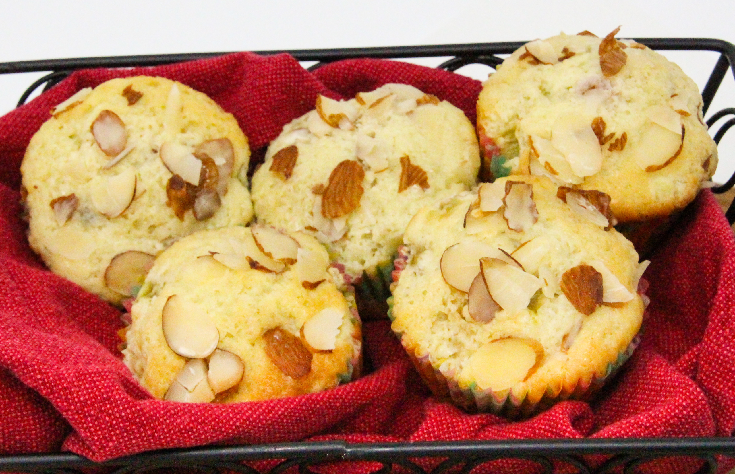 Bits of ruby red rhubarb is studded throughout these Rhubarb Almond Muffins, making them extra moist with a tart bite. Almond flavoring and sliced almonds sprinkled on top of the muffin brings a delicate flavor that complements the fruit. Recipe shared with permission granted by Leslie Budewitz, author of TO ERR IS CUMIN. 