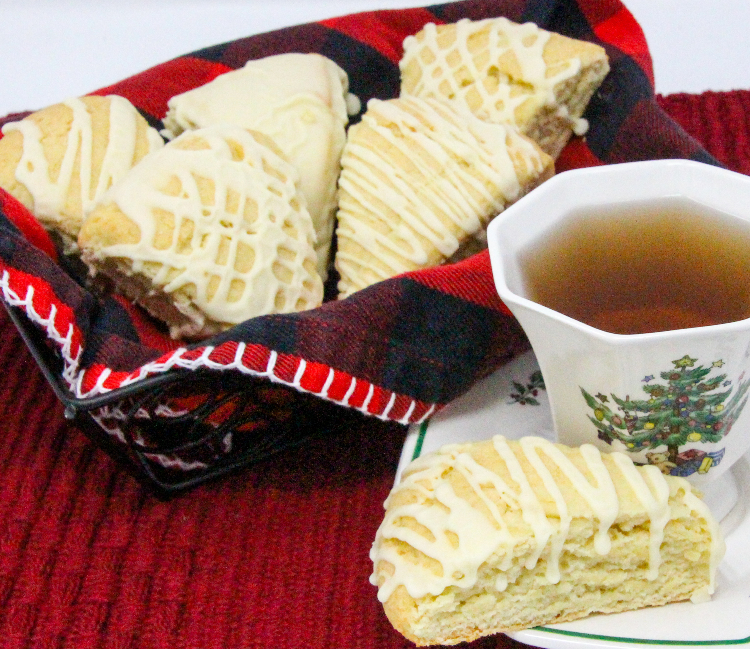 Eggnog Scones are flaky, melt-in-your-mouth pastry flavored with the quintessential holiday beverage! While the recipe doesn't use the usual huge amount of butter, the richness of the eggnog keeps these tender and with the eggnog flavored glaze, you don't even need to serve these with other accompaniments, unless you want to. Recipe shared with permission granted by Debra Sennefelder, author of A CORPSE AMONG THE CAROLERS.