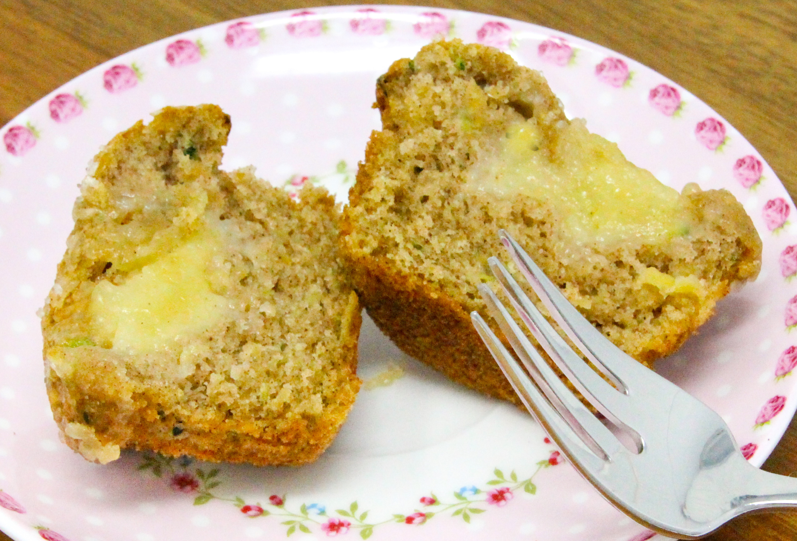 Apple Muffins with an Added Surprise are super moist, thanks to both apple and zucchini used in the batter. The cinnamon adds a nice flavor while the cream cheese filling adds richness. Recipe shared with permission granted by Lois Winston, author of SEAMS LIKE THE PERFECT CRIME.