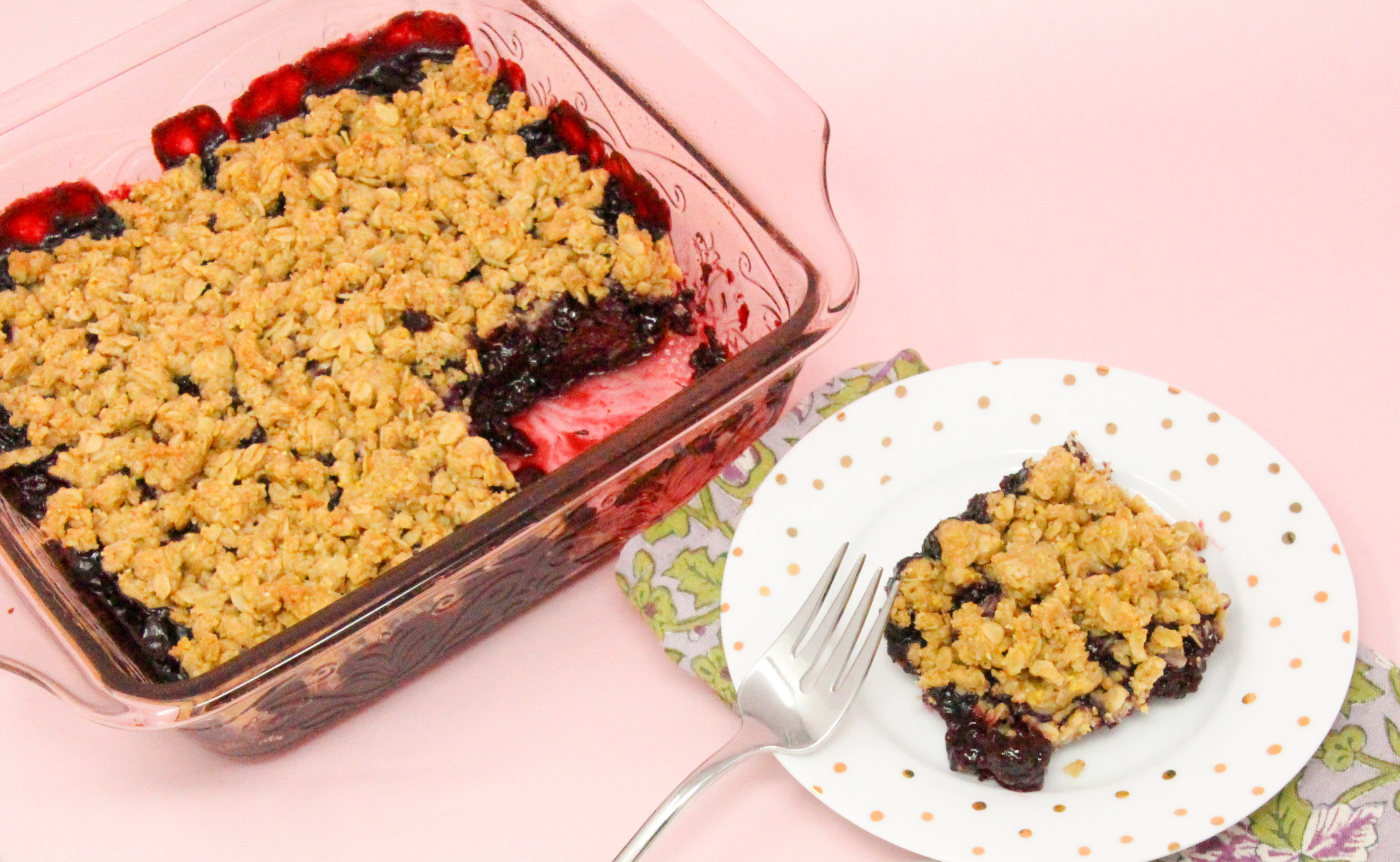 Blackberry Crumble Cobbler starts with a sweetened layer of juicy blackberries then topped with a crunchy oat and cornmeal crumble. Delicious on it's own, it's summery perfection when served with ice cream! Recipe shared with permission granted by Gigi Pandian, author of THE LIBRARY GAME.