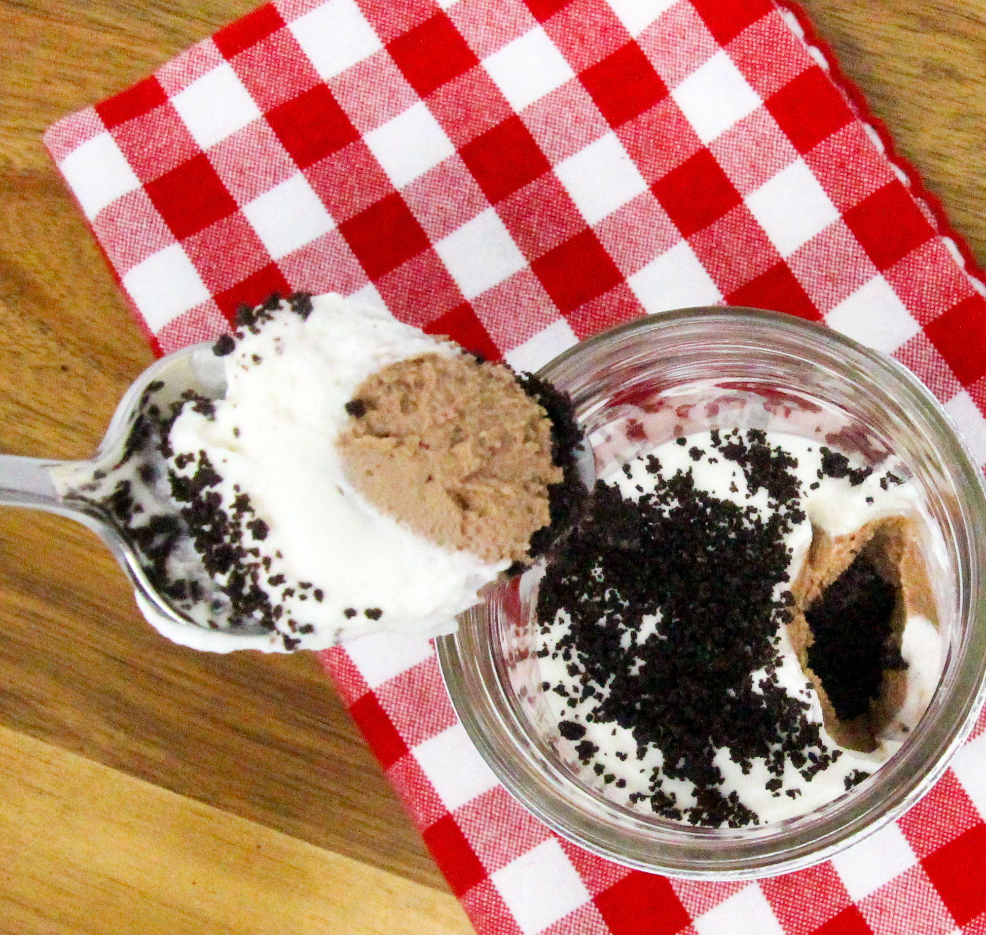 No-Bake Chocolate Cheesecake Jars are super easy-peasy to make with an Oreo crumb base. The delectable combination of chocolate, cream cheese, cream, sugar, and vanilla creates a silky layer of chocolate cheesecake, topped by cream cheese whipped cream. Layered in small mason jars, the presentation is fun and practical for easy serving for gatherings. Recipe shared with permission granted by Korina Moss, author of BAIT AND SWISS.